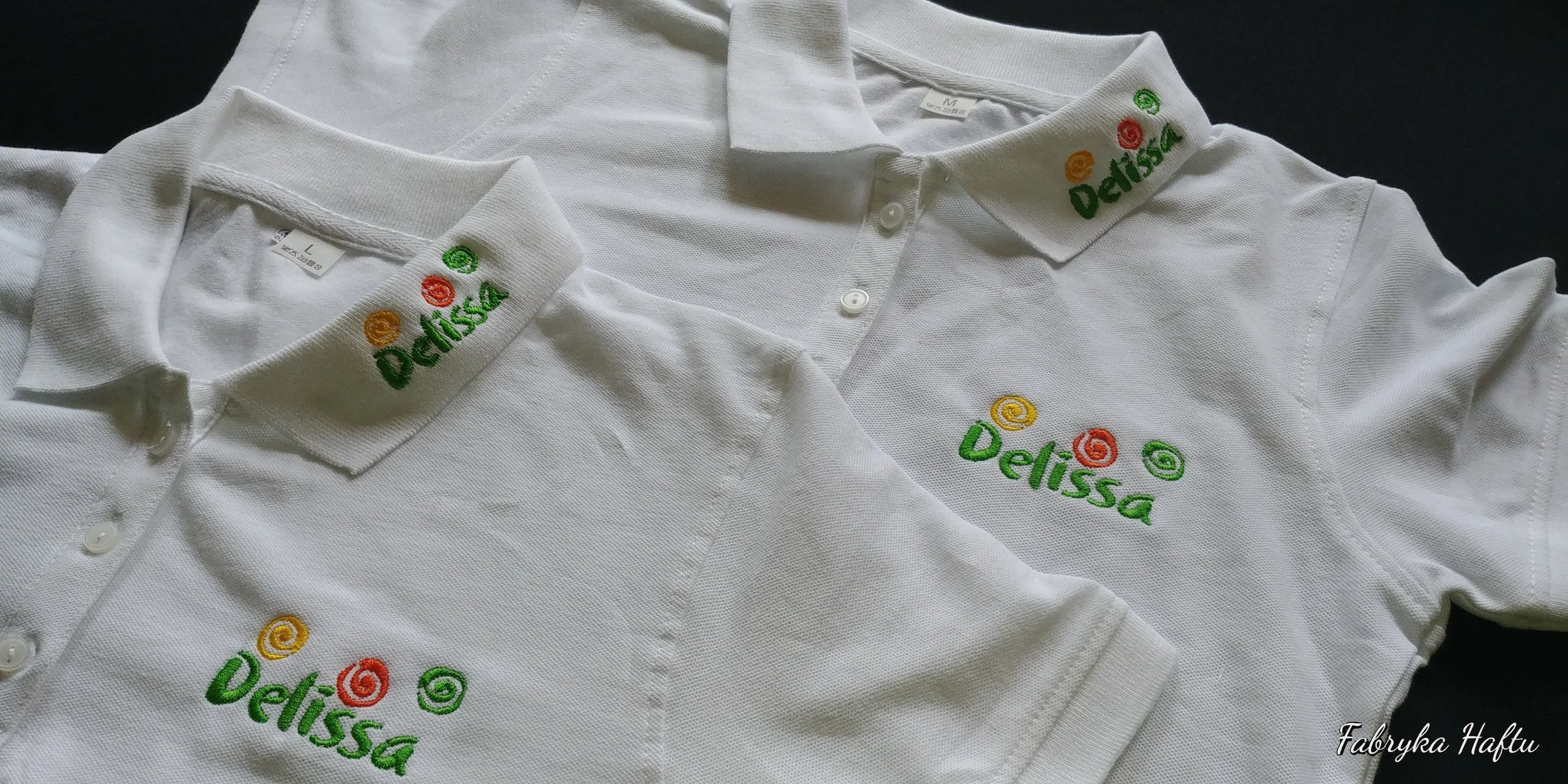 White polo shirts with embroidered colorful swirl designs and the word "Delissa" on the collar and chest area.