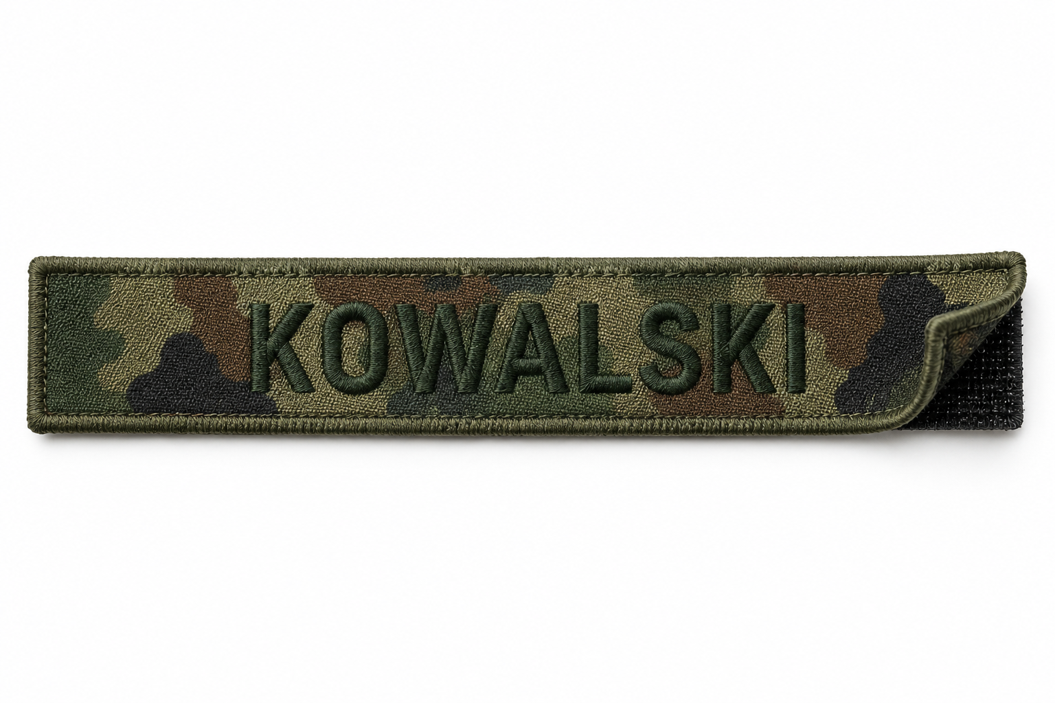 Imiennik wojskowy wz. 93 z oliwkową ramką i nazwiskiem haftowanym w ciemnozielonym melanżu.