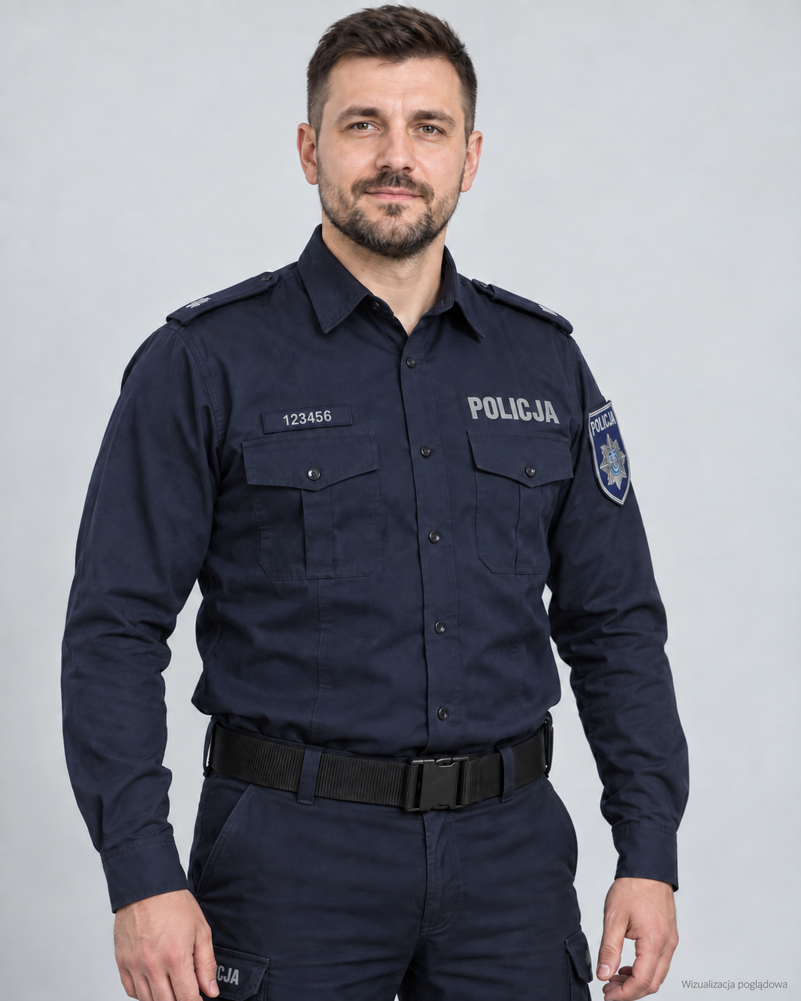 A male police officer in uniform standing against a plain gray background.