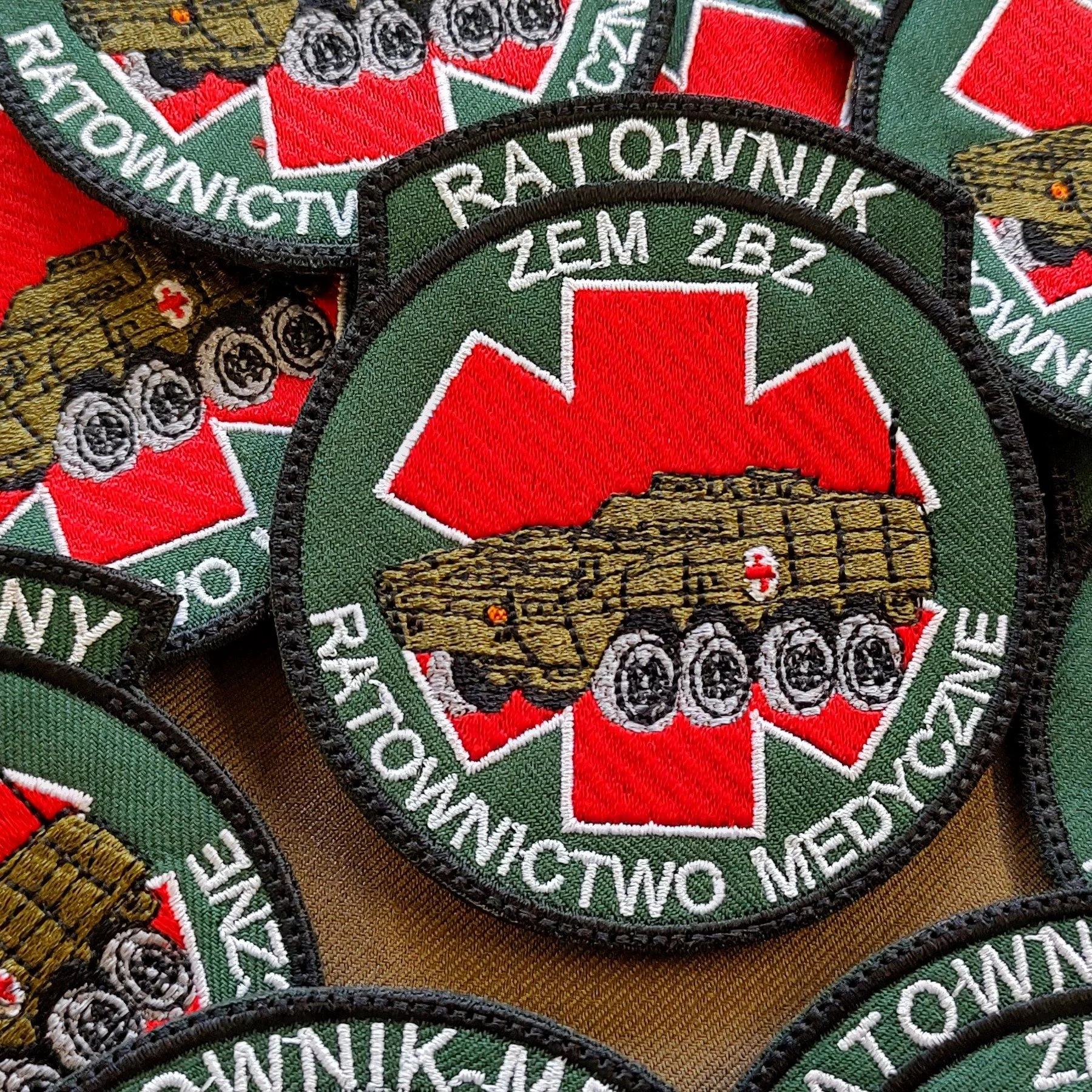 Okrągłe naszywki ZEM 2BZ z wojskowym pojazdem medycznym na czerwonej gwieździe życia