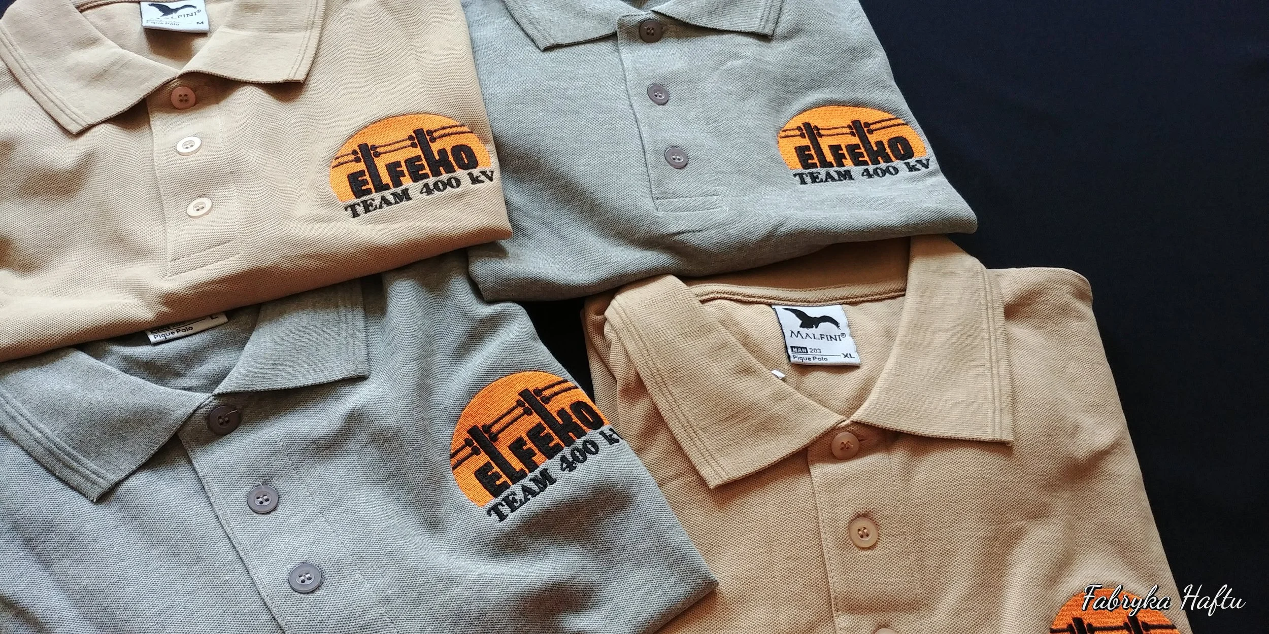Multiple folded polo shirts in beige and gray with embroidered patches that say 'elfeko TEAM 400 KV' on the chest, arranged on a black surface.