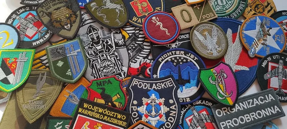 A collection of various military and organizational patches, badges, and insignias, including patches featuring helicopters, aircraft, and military emblems.