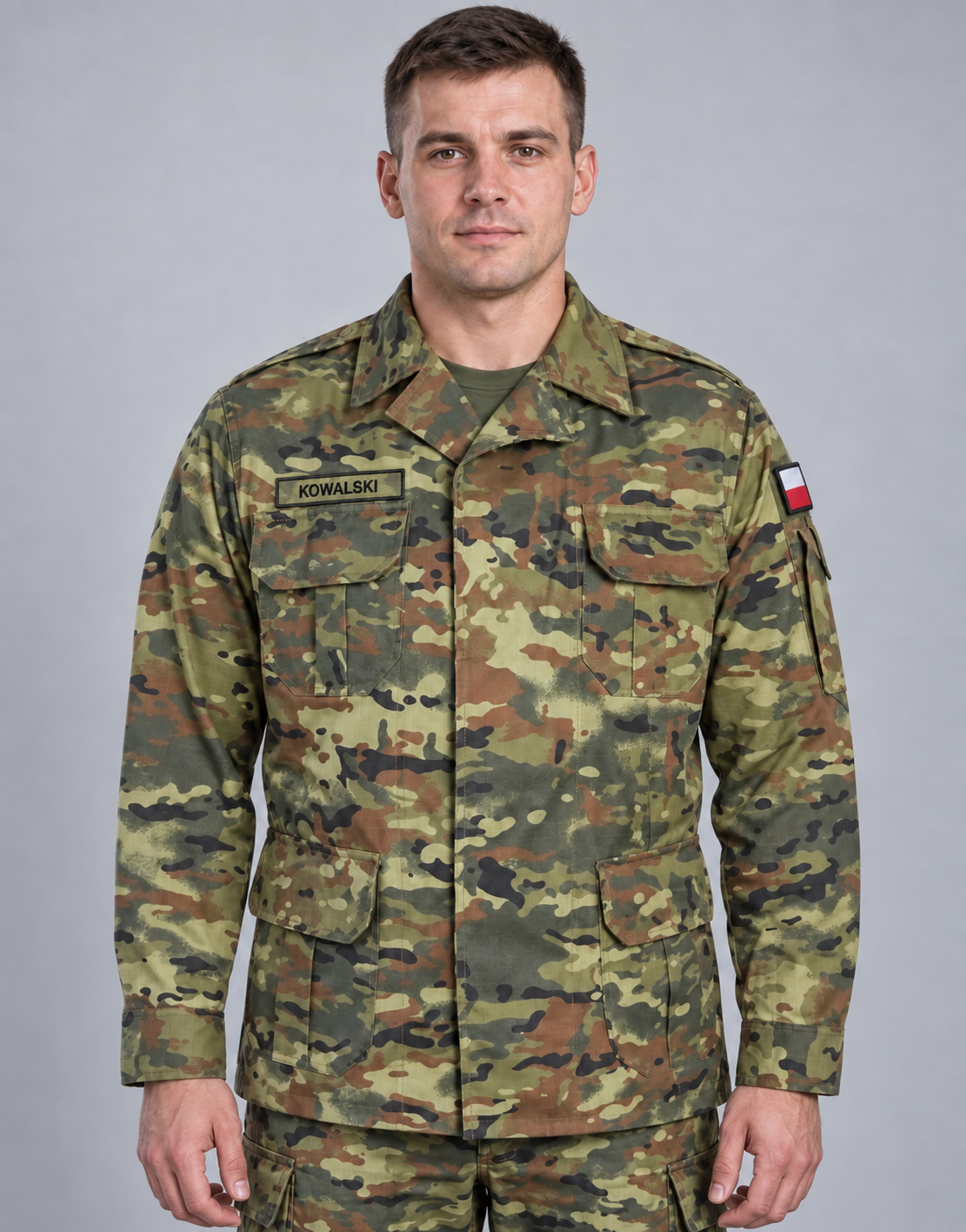 A man in military uniform with a name tag 'KOWALSKI' standing against a plain gray background.