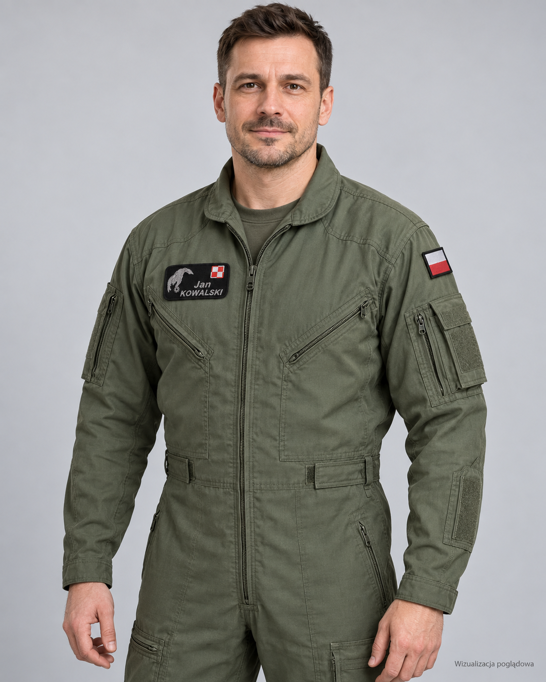 Photo of a man wearing a green military flight suit with patches, one showing the Polish flag and a name tag reading Jan Kowalski, standing against a plain light gray background.