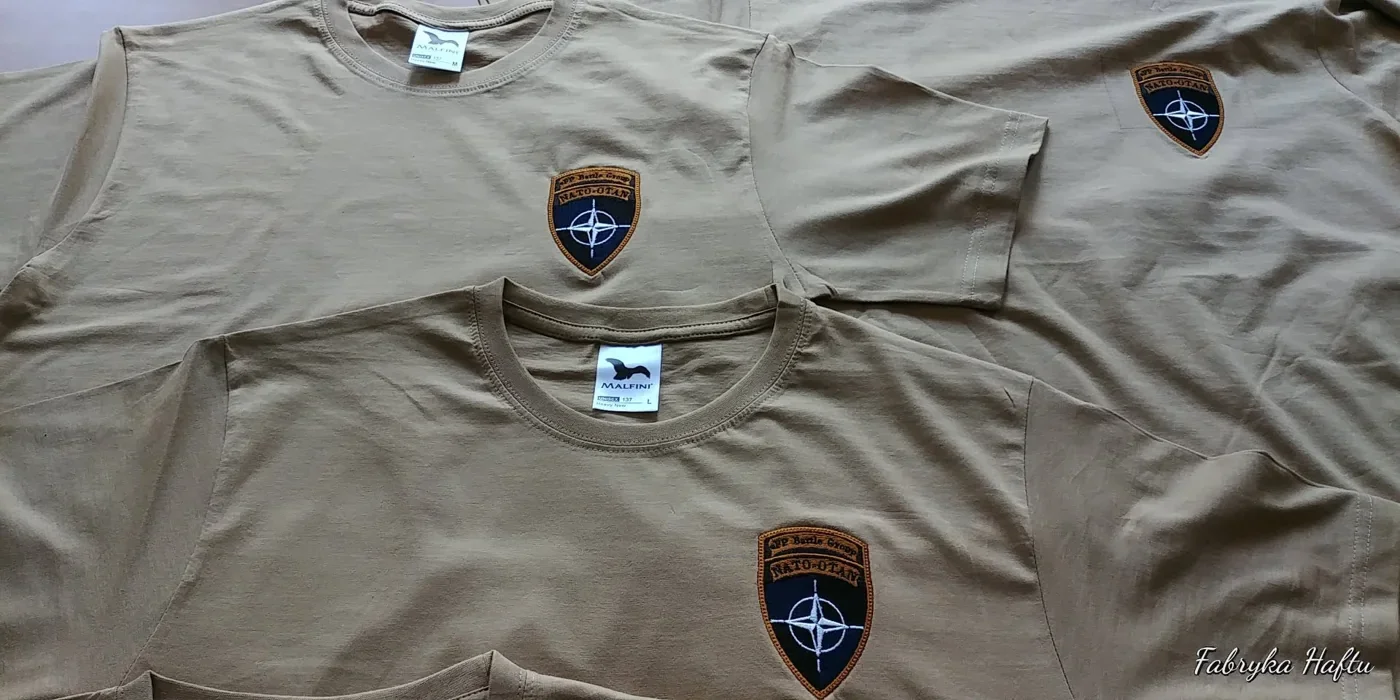 Koszulki khaki z haftowanym oznaczeniem eFP Battle Group NATO-OTAN na piersi z produkcji Fabryki Haftu Ełk
