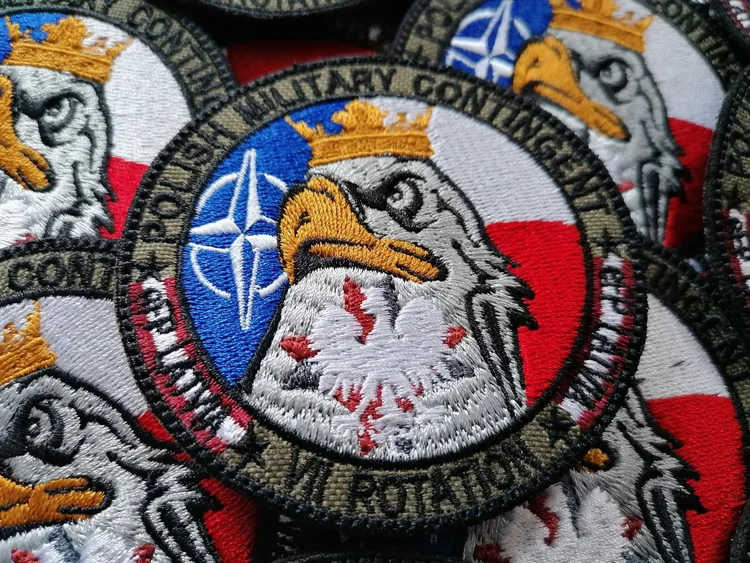 Naszywki z napisem Polish Military Contingent, haftowanym orłem oraz symbolami Polski i NATO.