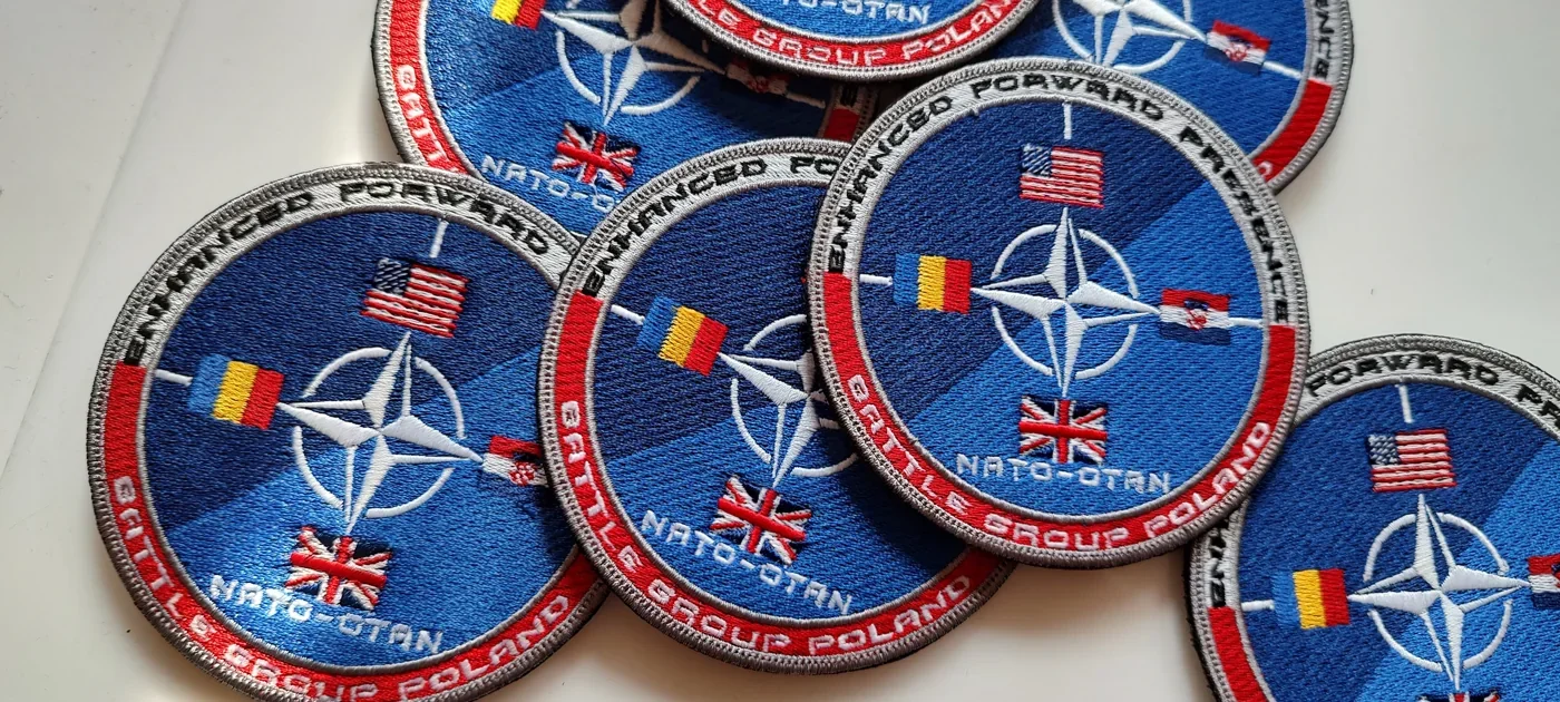 Okrągłe naszywki z symbolem NATO i flagami państw wykonane dla żołnierzy