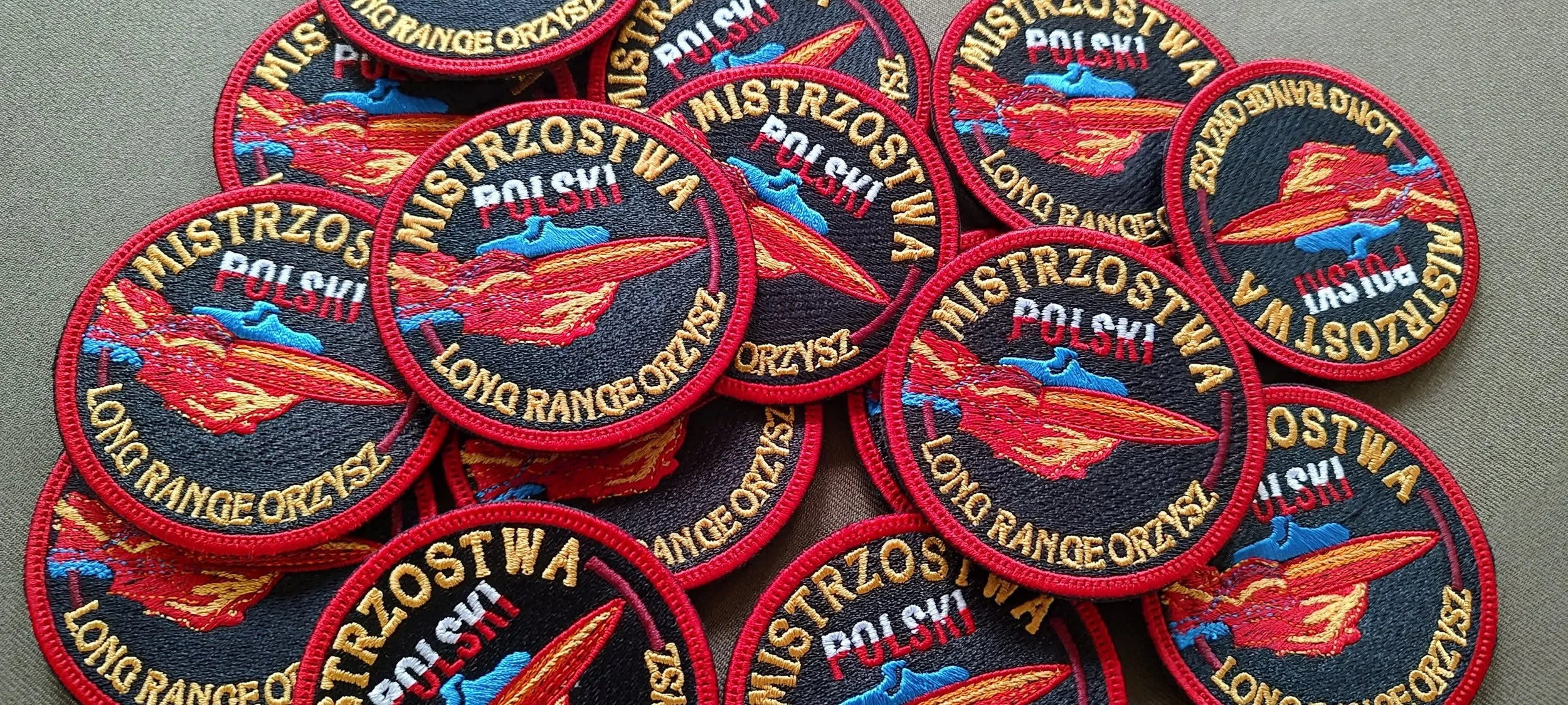 Haftowane naszywki Mistrzostw Polski Long Range Orzysz z czerwonym pociskiem i złotymi napisami