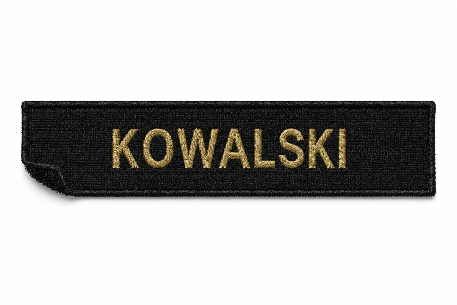 Black fabric name tag with gold embroidered text reading 'KOWALSKI'.