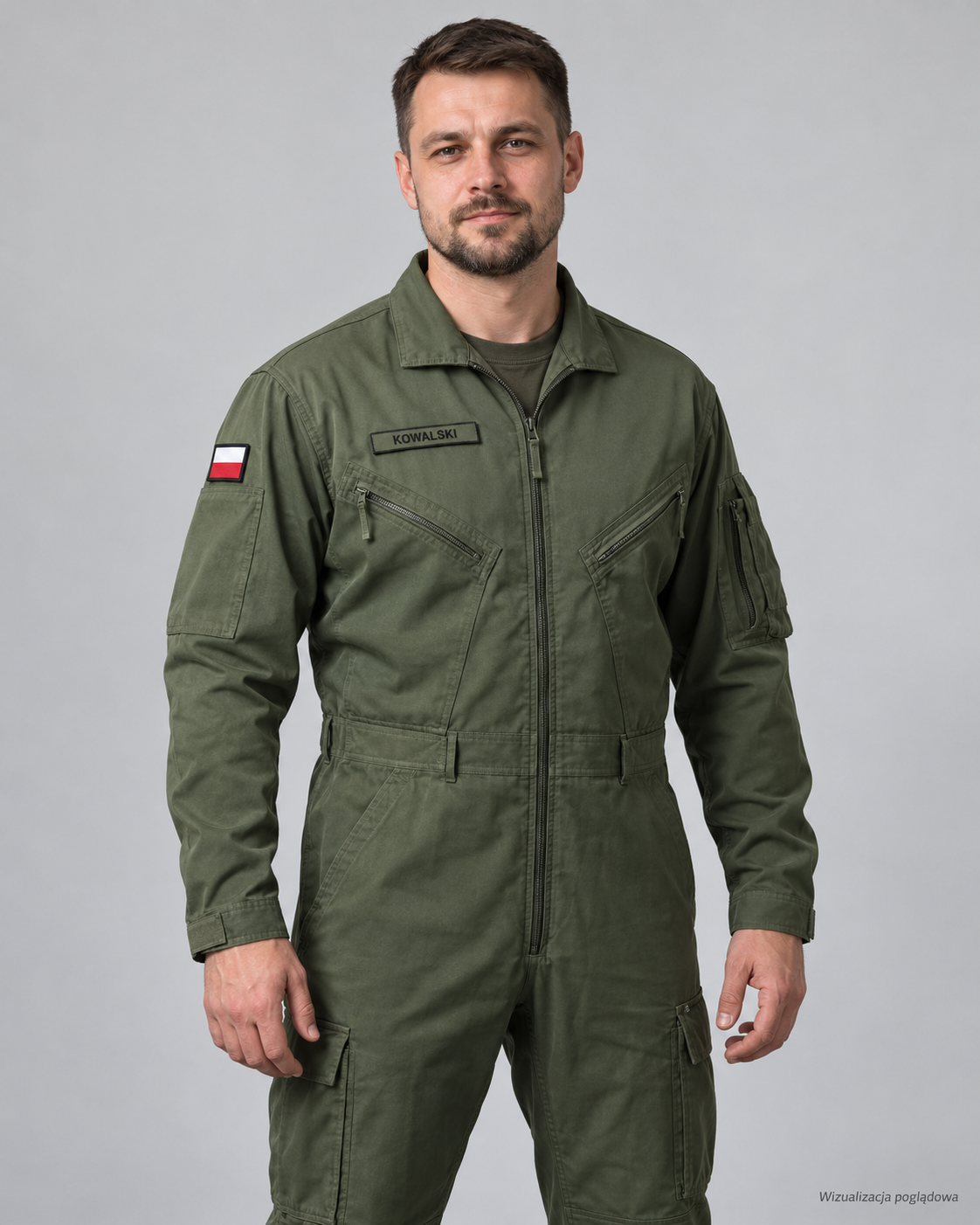 Man in green military or tactical jumpsuit with Polish flag patch on the shoulder, standing in front of a gray background.