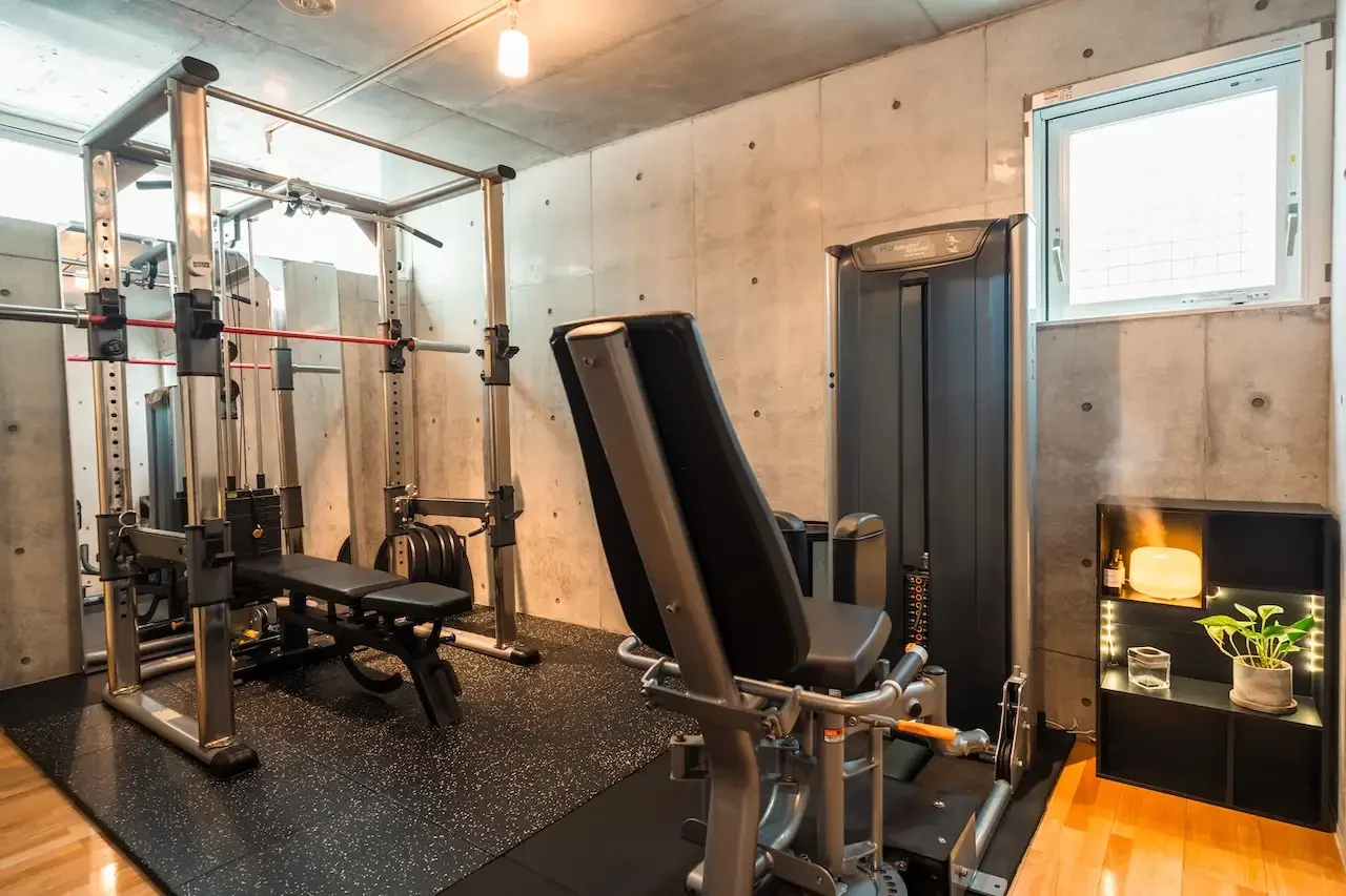 日吉駅徒歩3分の完全個室ジム「CLEAN.gym」のトレーニングルーム。清潔感のある白と黒を基調とした空間に、本格的なパワーラックを完備。