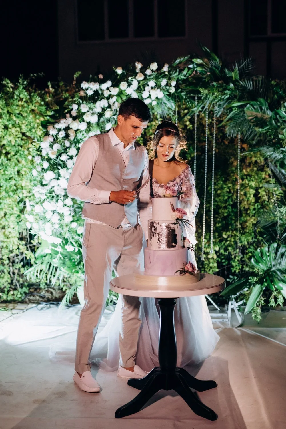 Laurie’s customers, Mariana and Carmen holding hands on a green lawn on their wedding day.