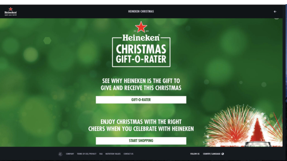 Heineken Christmas Gift-O-Rater webpage with a green bokeh background, red star logo at the top, and festive fireworks at the bottom right.