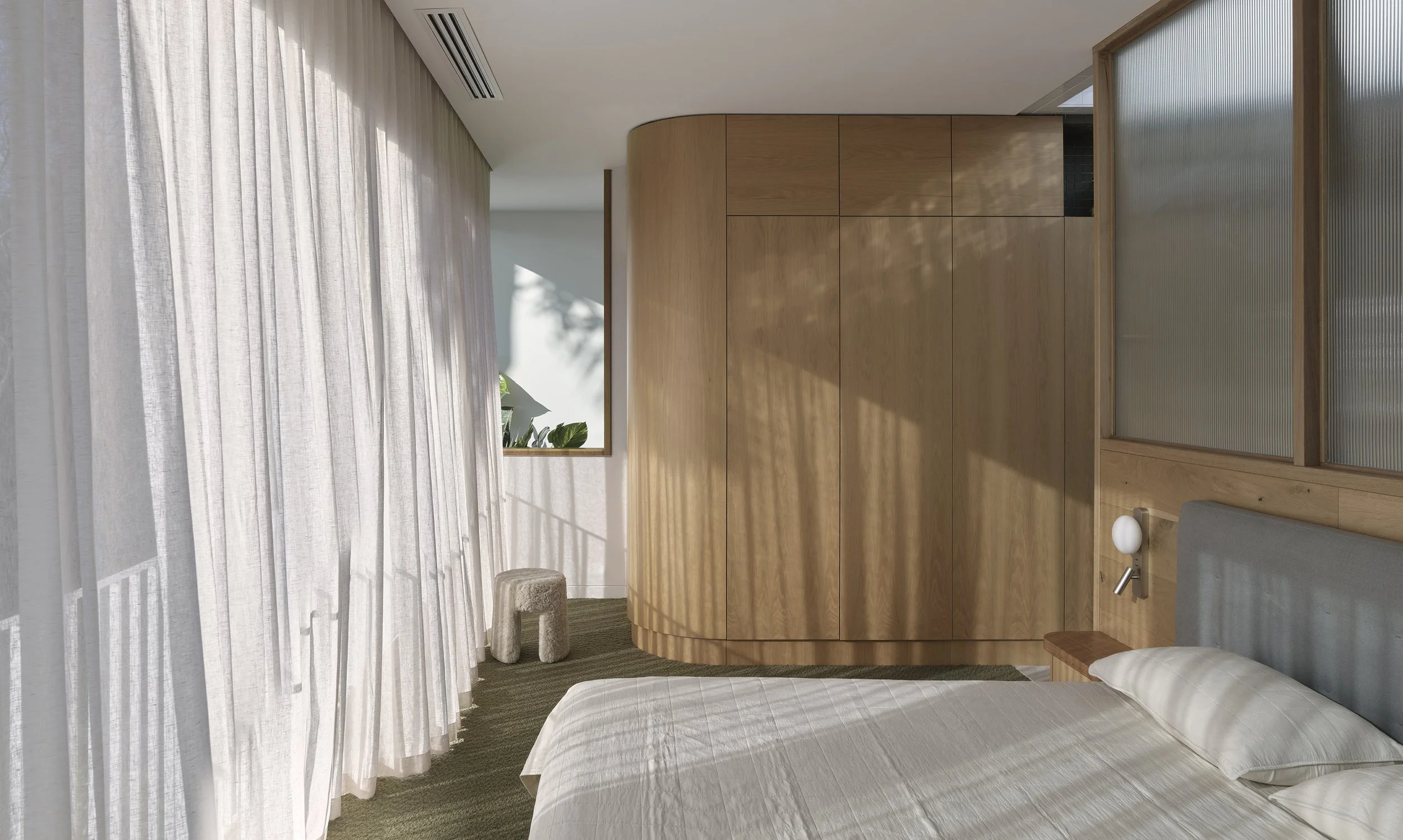 A minimalist bedroom with a bed, wooden wardrobe, white curtains, and natural light filtering in.