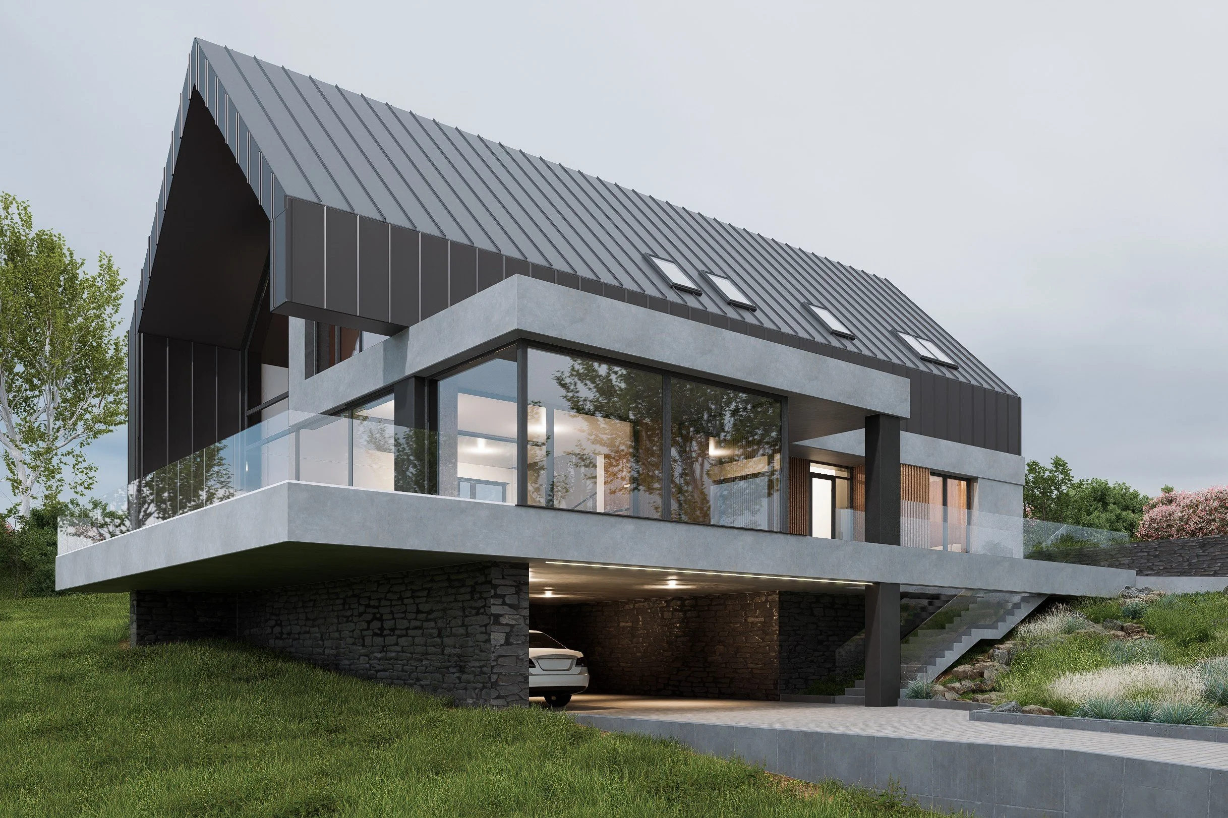 Modern house with glass balcony, black metal roof, and stone foundation, situated on a grassy hillside with trees and pink blossoms in the background.