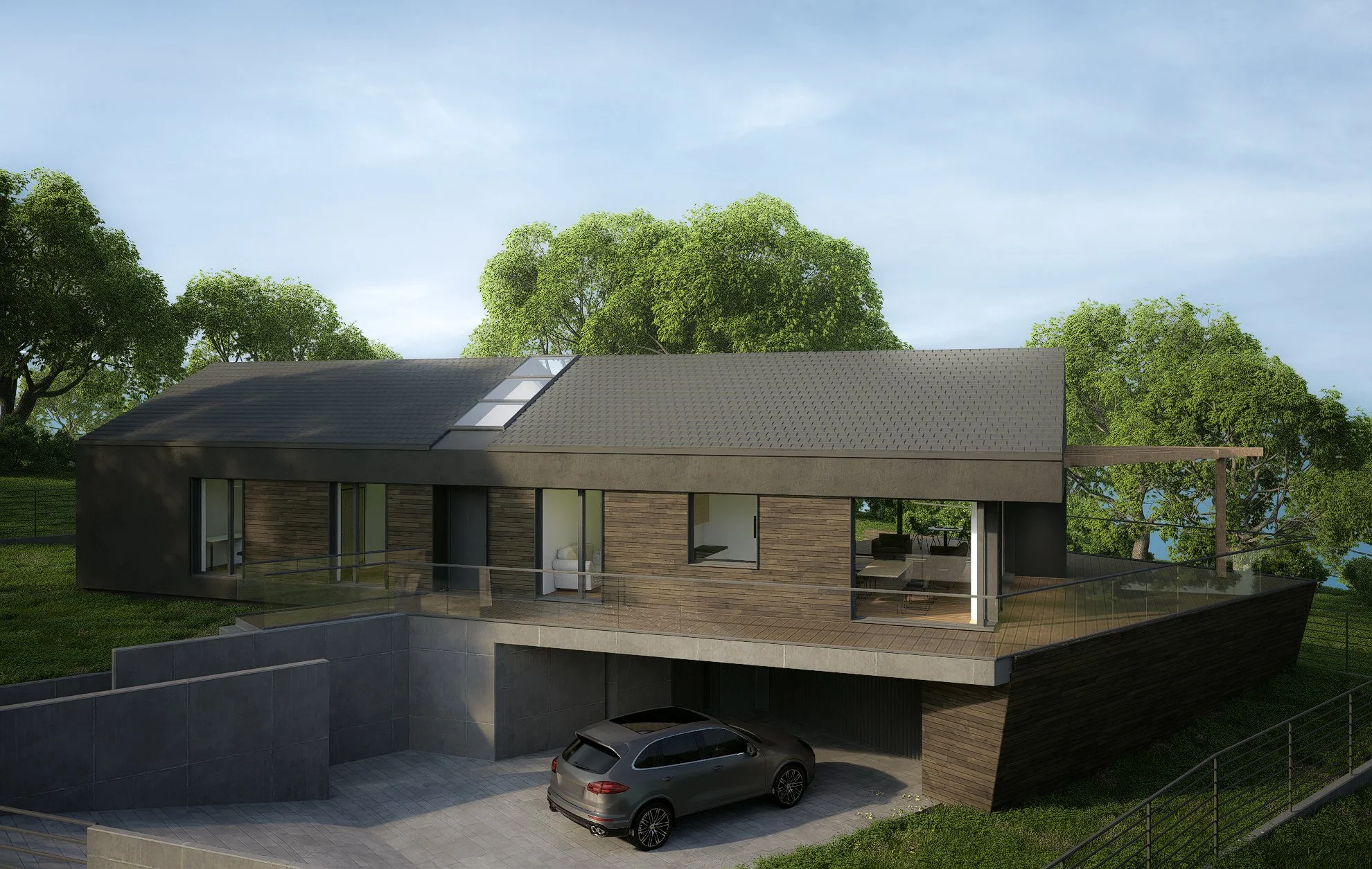 Modern house with a sloped roof, large windows, and a front balcony overlooking a driveway and garden area with trees in the background.