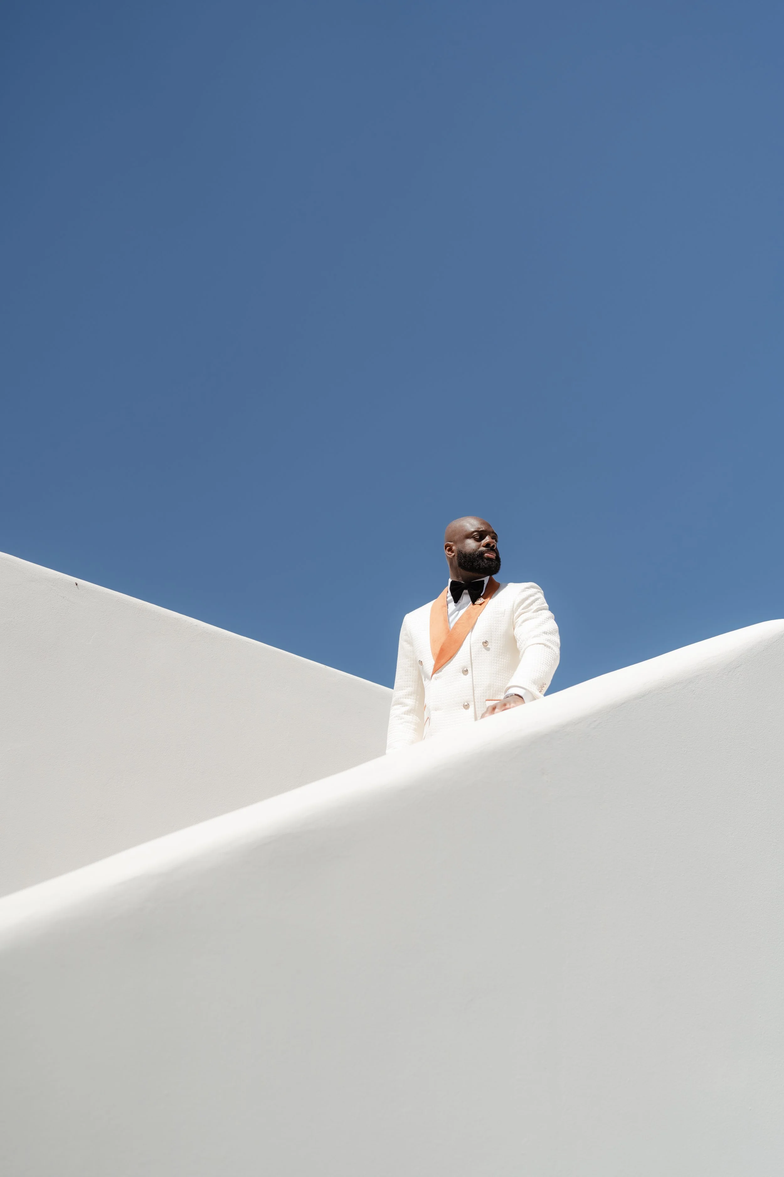 Luxury Groom Portrait in Santorini, Greece
A striking portrait of the groom against Santorini’s iconic white architecture and blue sky. A refined image that reflects the style of a luxury wedding in Greece.