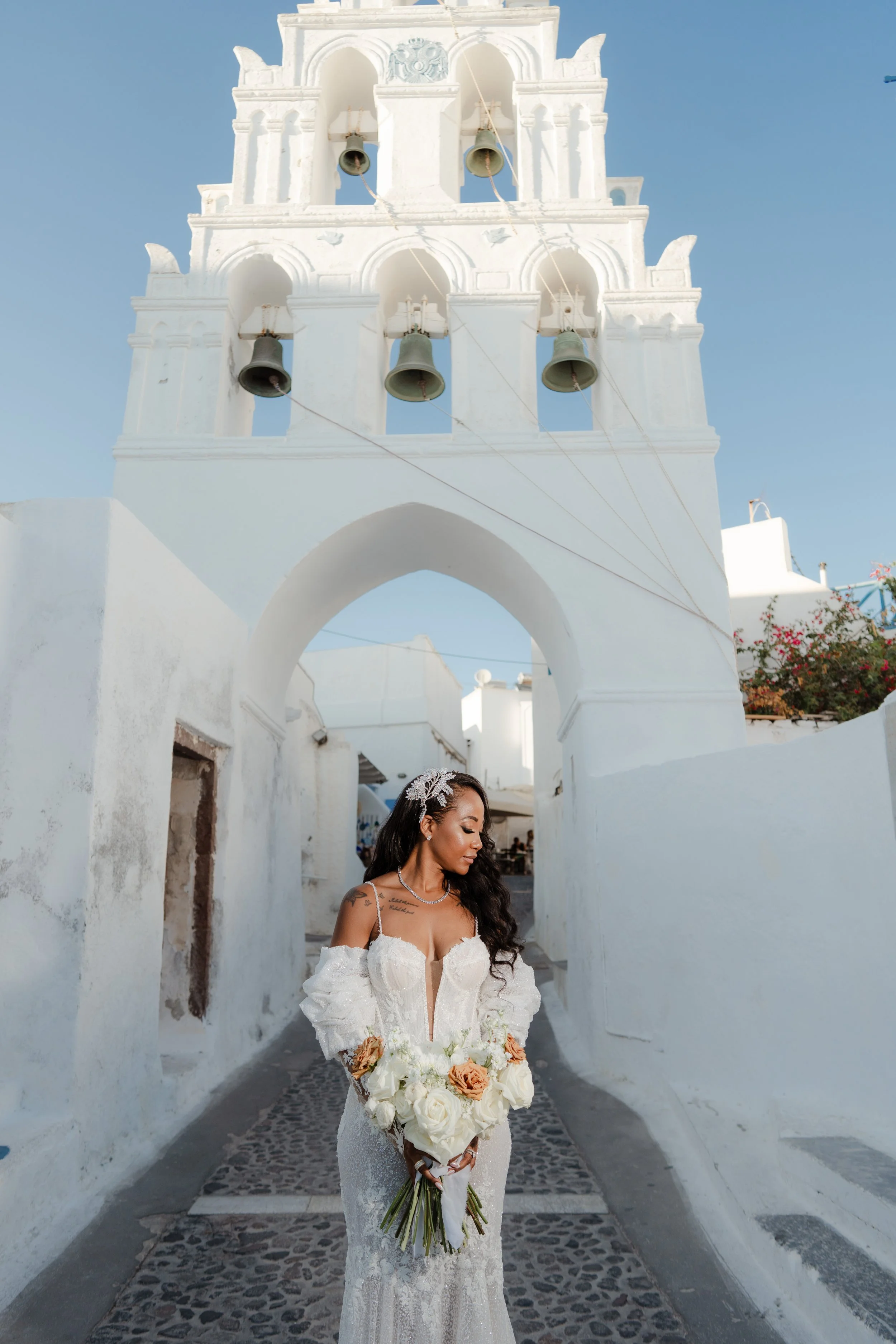 Luxury Bride Portrait in Santorini, Greece
The bride poses under a traditional white arch in Santorini. A radiant and elegant moment from a luxury wedding in Greece.