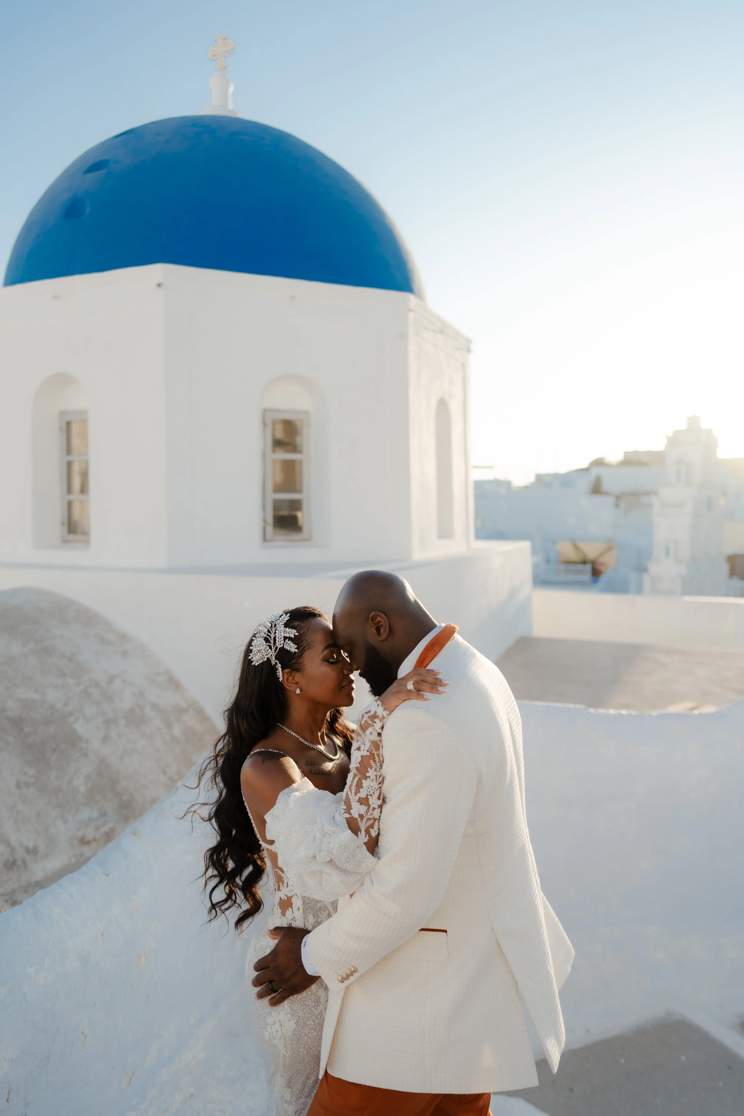 Luxury Wedding Photoshoot in Santorini, Greece
The bride and groom share a romantic moment by a traditional blue-domed chapel. An iconic image that defines the beauty of a luxury wedding in Greece.