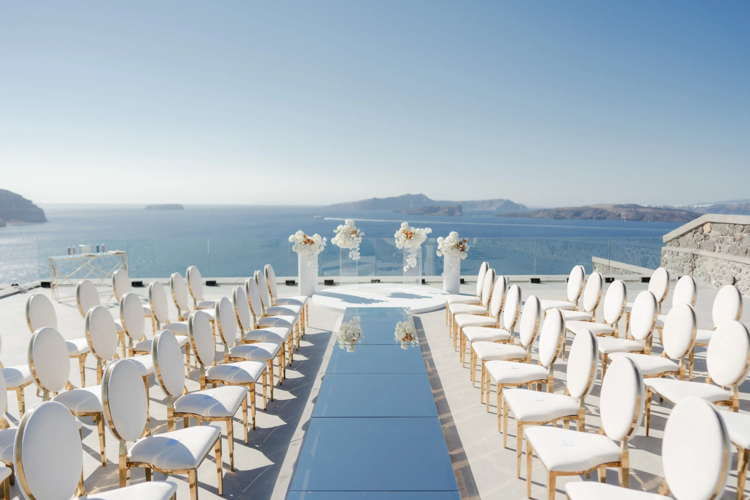 Luxury Wedding Ceremony in Santorini, Greece
An elegant ceremony aisle framed by white florals and the Aegean Sea. A breathtaking luxury wedding setup in Santorini, designed for a refined destination celebration in Greece.