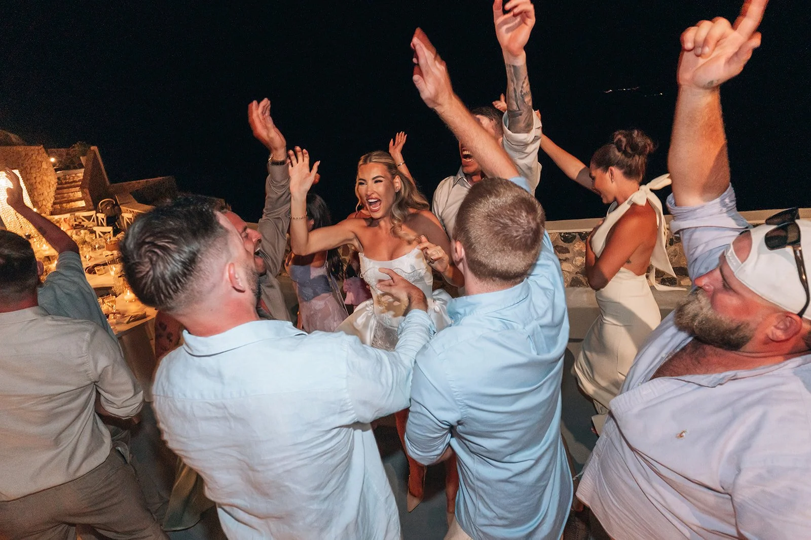Guests dancing and celebrating with joy at the wedding party, creating unforgettable memories in Santorini.