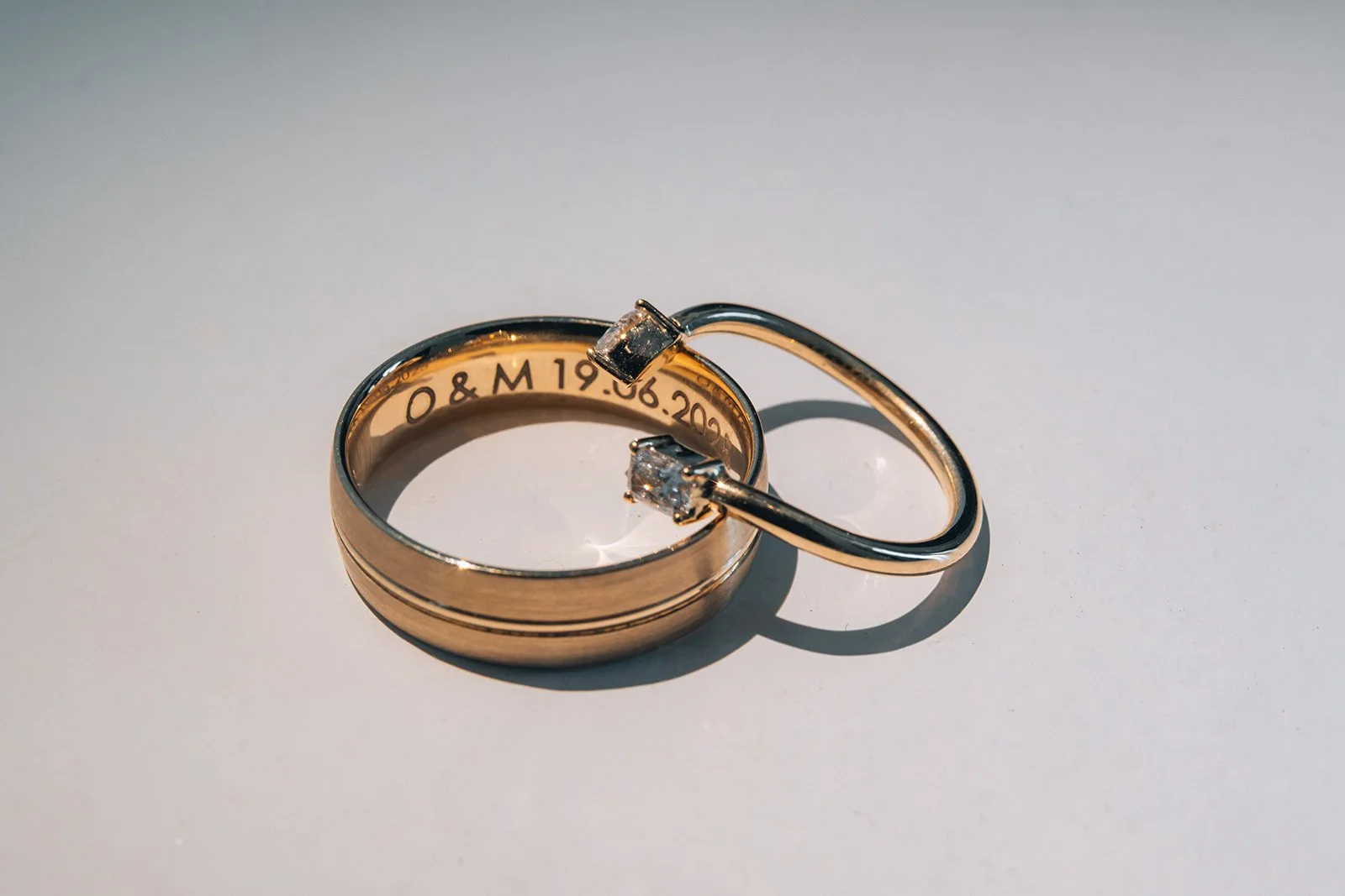 Close-up of luxury gold wedding rings, symbolizing eternal love in a chic Santorini destination wedding.