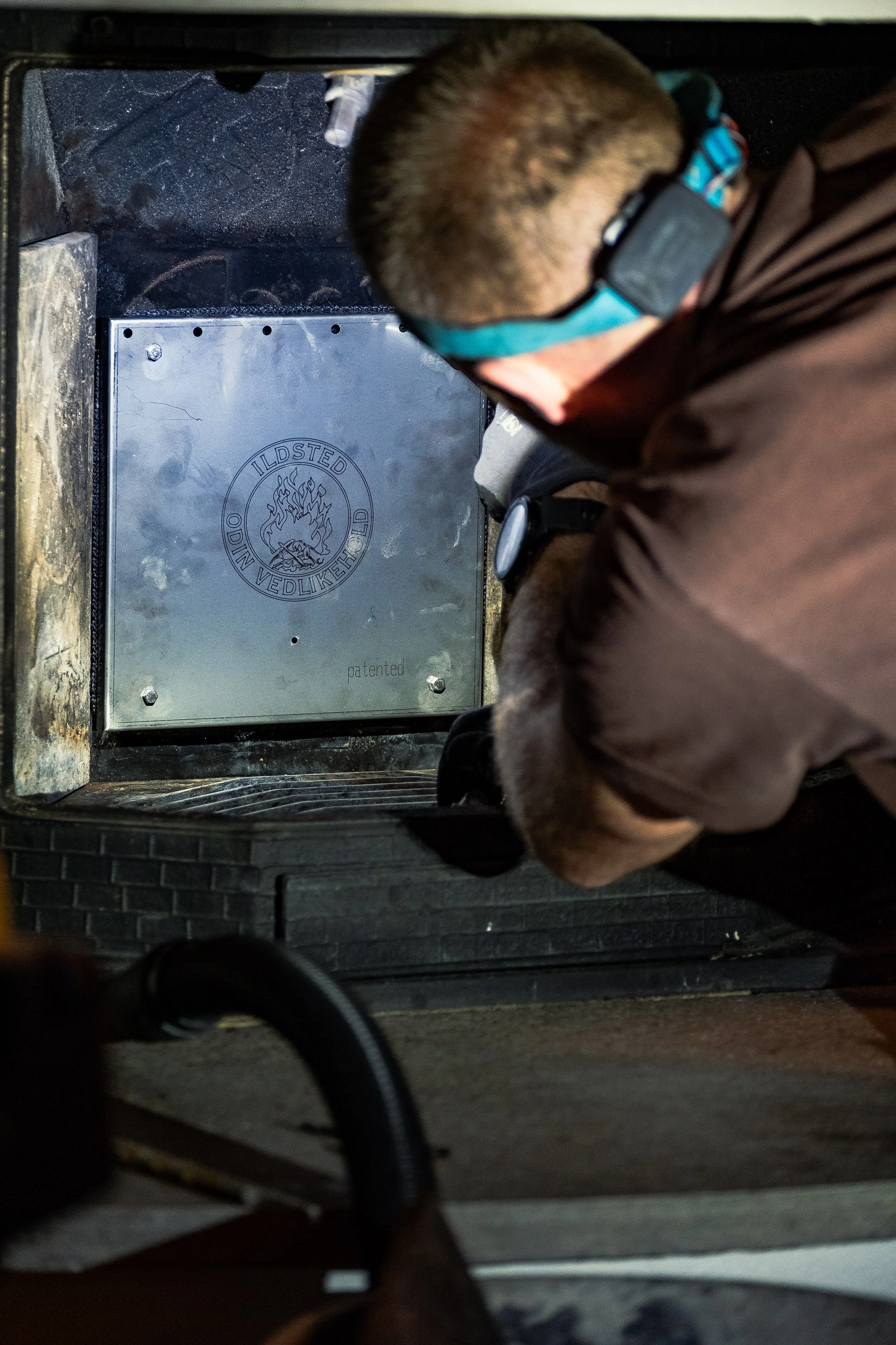 Montør fester etterbrenner inn i gammel peisovn.