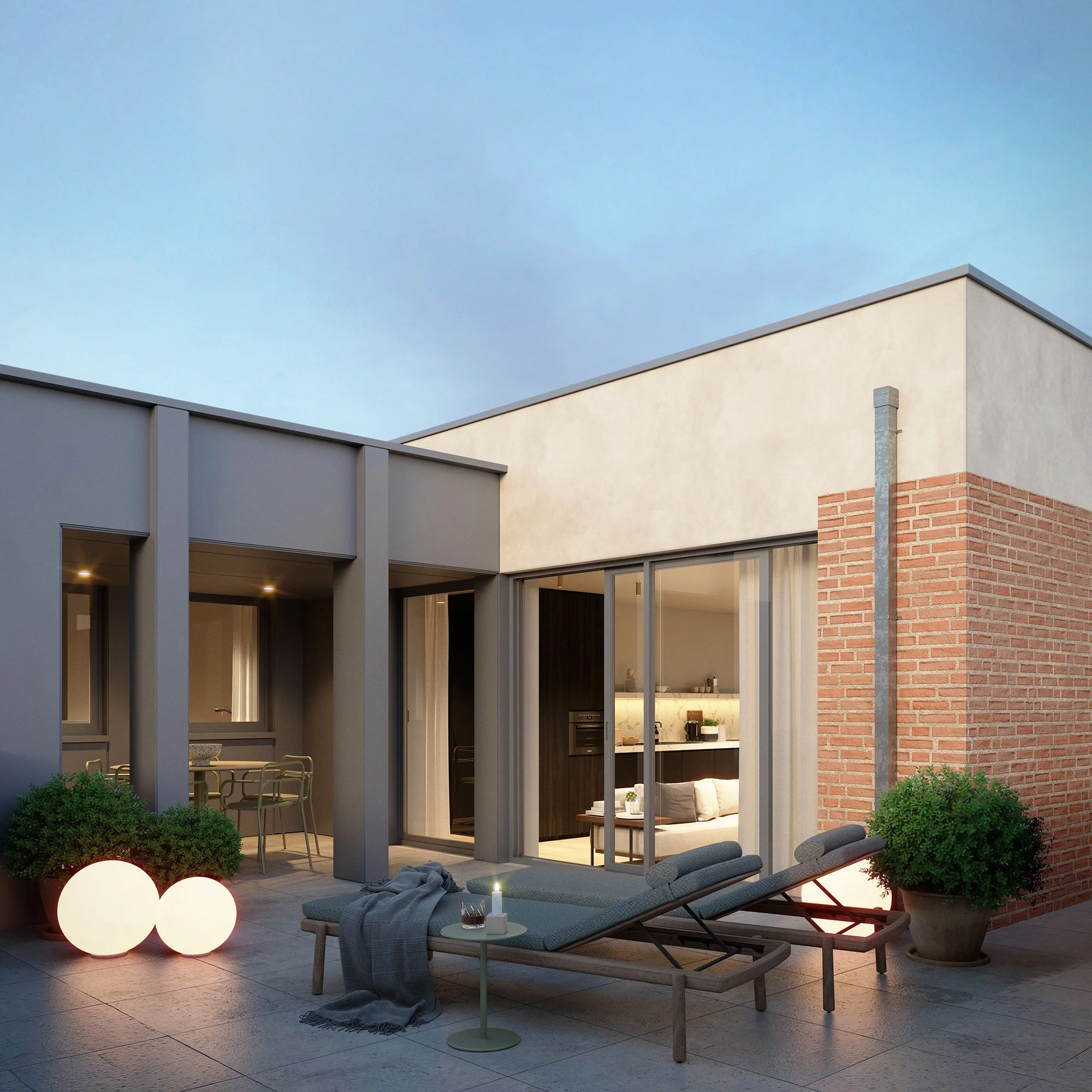 Moderne achtertuin met loungeset, lage tafel, grote plantenpotten, verlichte lantaarns, en een overdekt terras met keukentje, in de avond. Buitenkant van een huis met grote ramen en een combinatie van beton, baksteen en hout.