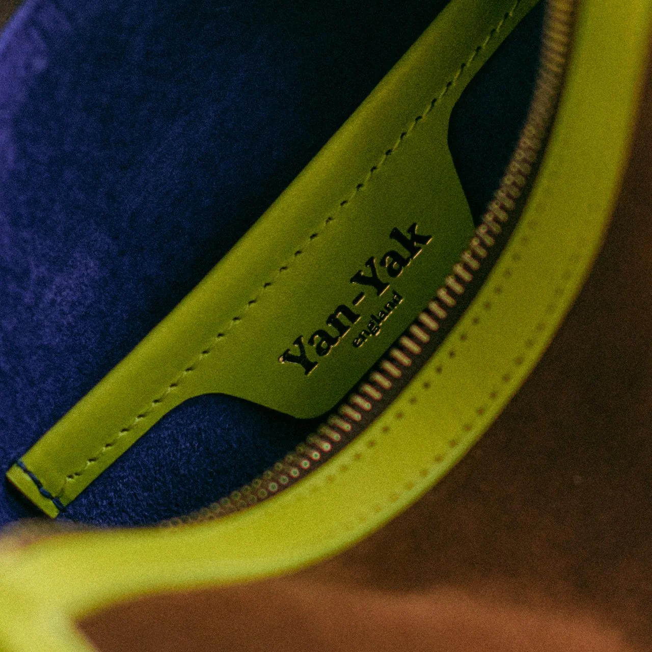 Close-up of a yellow fabric label inside a bag, with black text that reads "Yan Yak" and smaller text below that reads "England".