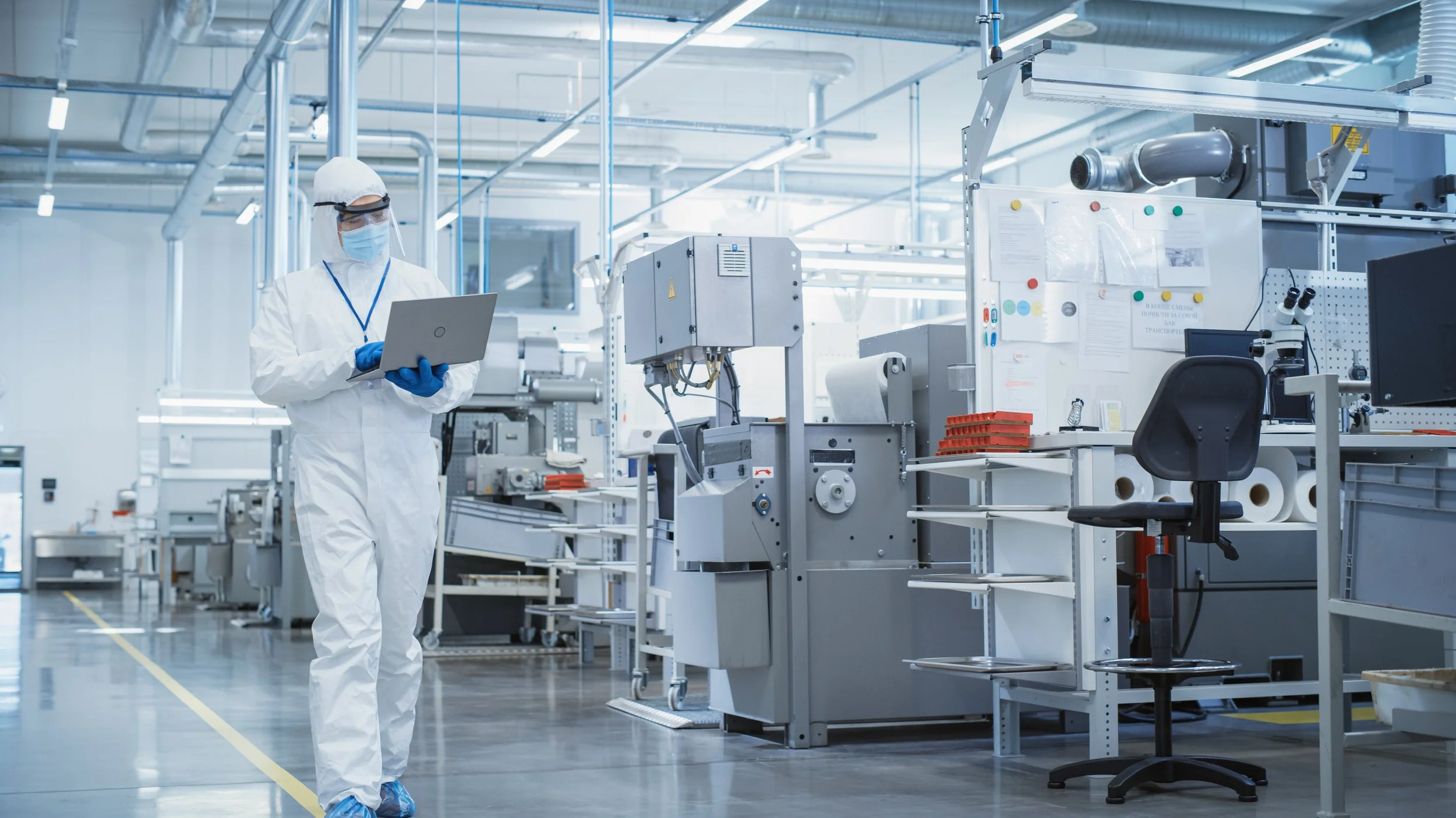 Scientist wearing protective gear working with machinery in a modern laboratory.