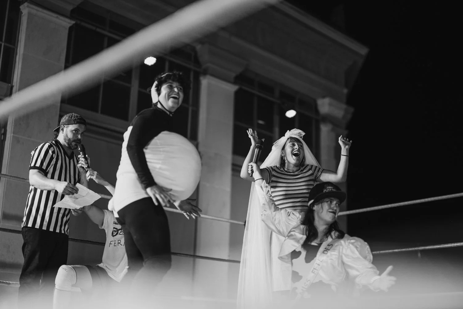 People in a wrestling ring dressed in costumes capturing a lively moment