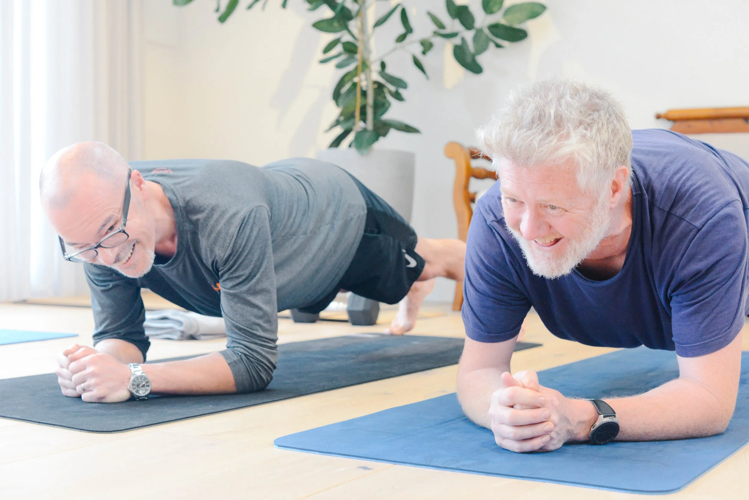 Two men doing exercise in a Fab Over 40 Wellbeing exercise class in Driftwood studio. 