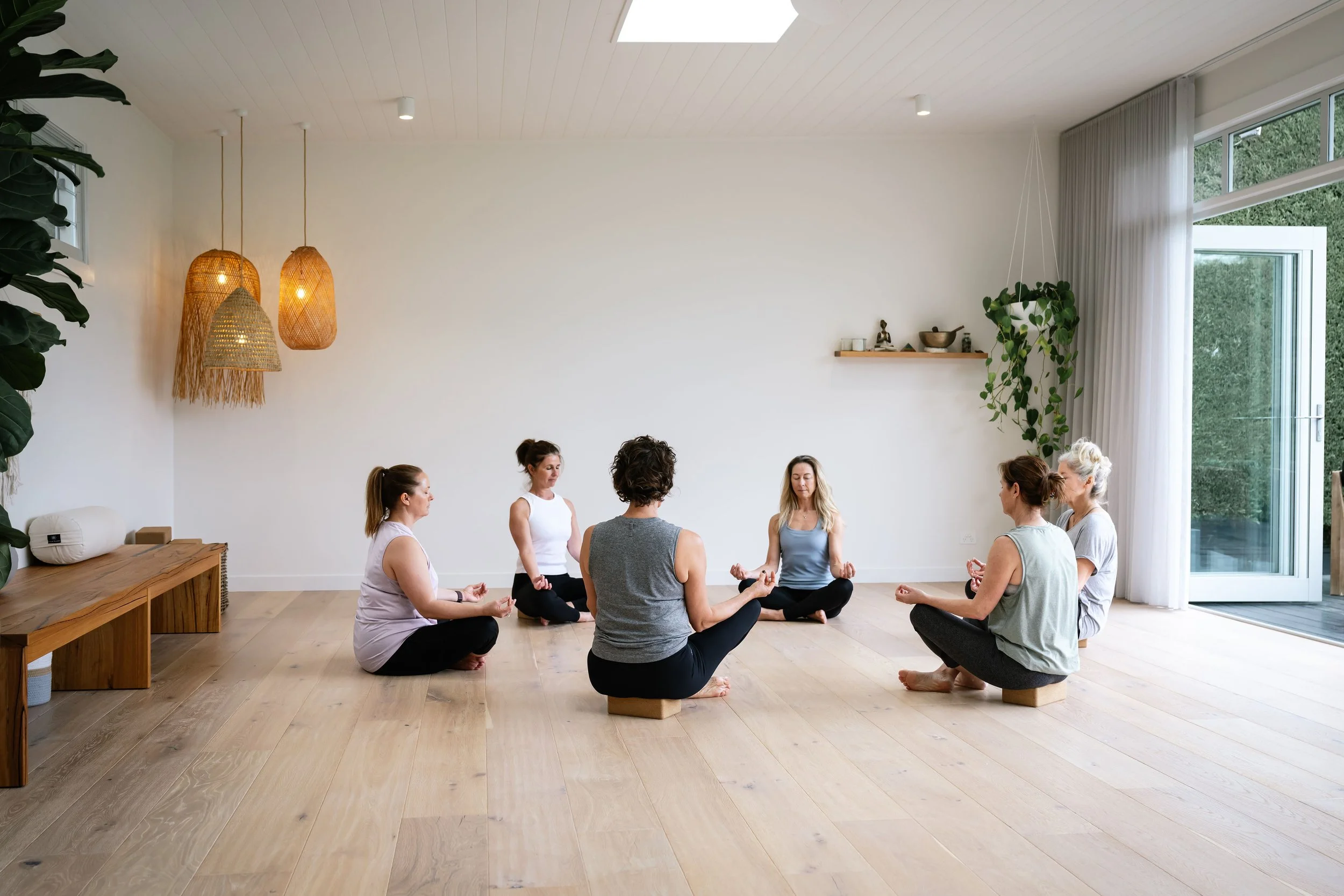 A group of seven women over 40 practicing meditation on a day yoga retreat at Driftwood studio Mt Eliza. 
