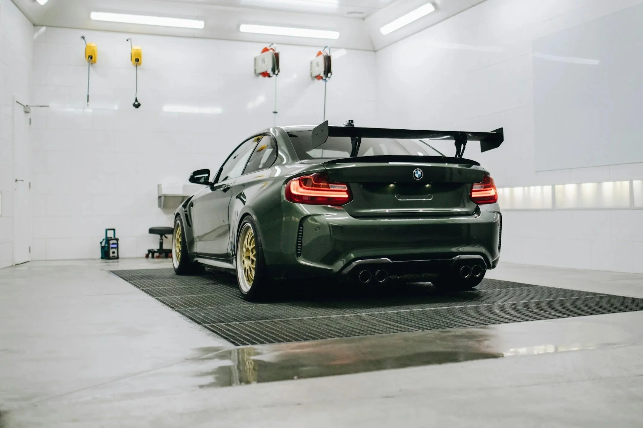 A clean BMW sports car in a professional detailing garage after a car wash.