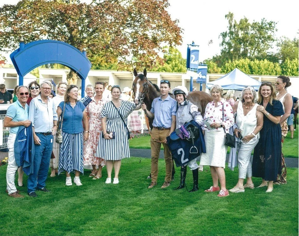 Glitterati winning for the No Fun Winning Alone syndicate at Windsor. Thge Syndicate are enjoying celebrating in the evening sun after the win