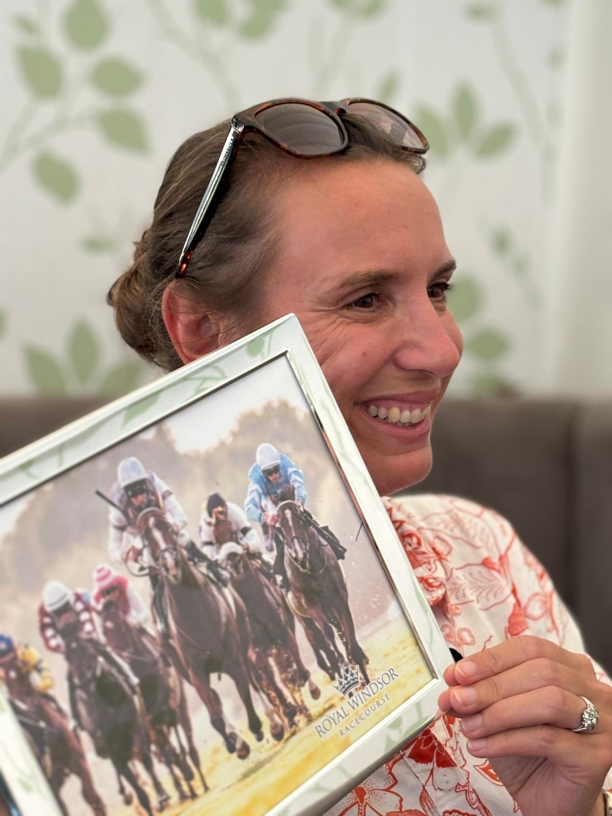 Sophie Buckley holding a picture of Glitterati winning at Windsor racecourse for the No Fun Winning Alone Syndicate