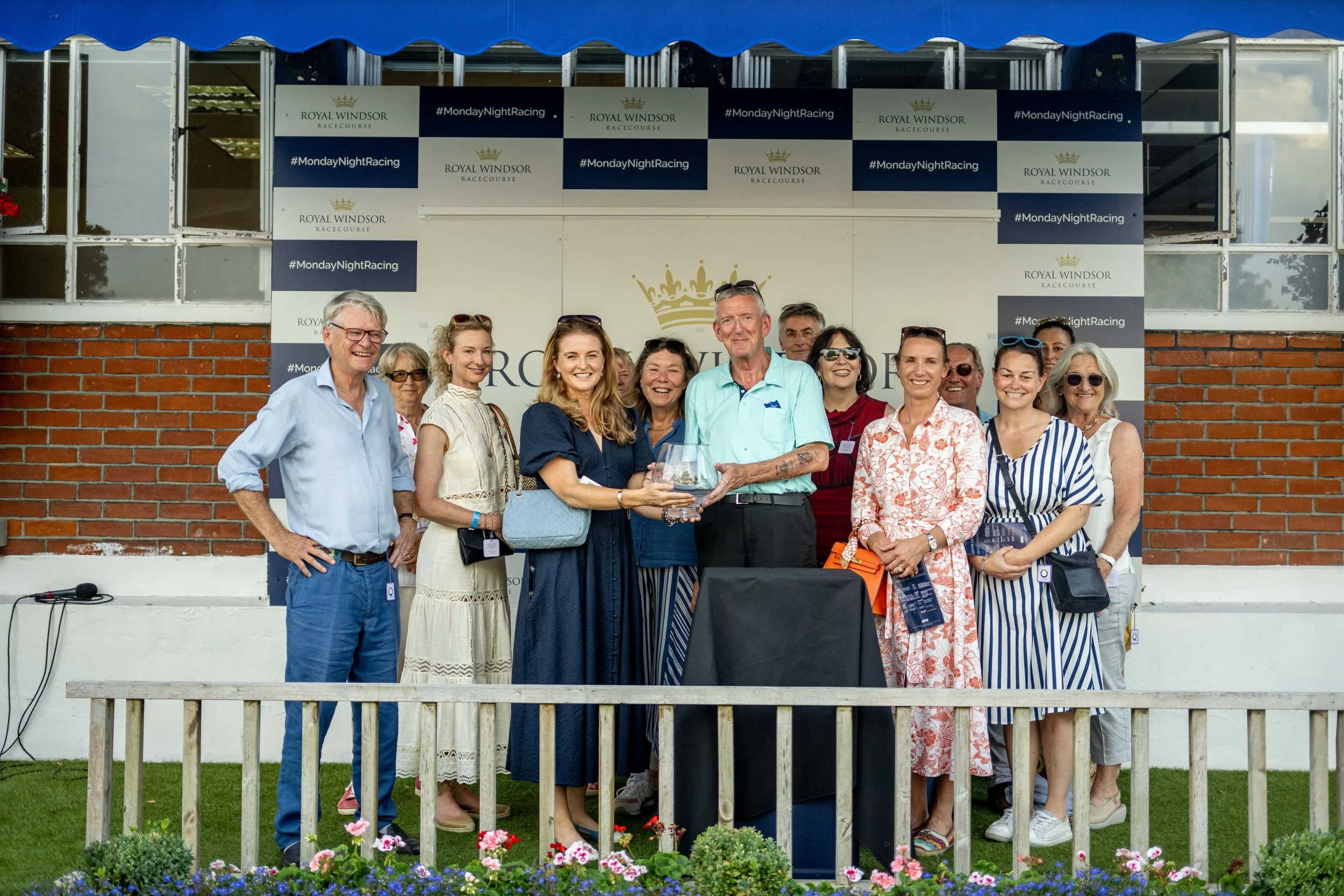 A link to the About Us page with a picture of the No Fun Winning Alone syndicate in the Winners ensclosure at Windsor with Glitterati