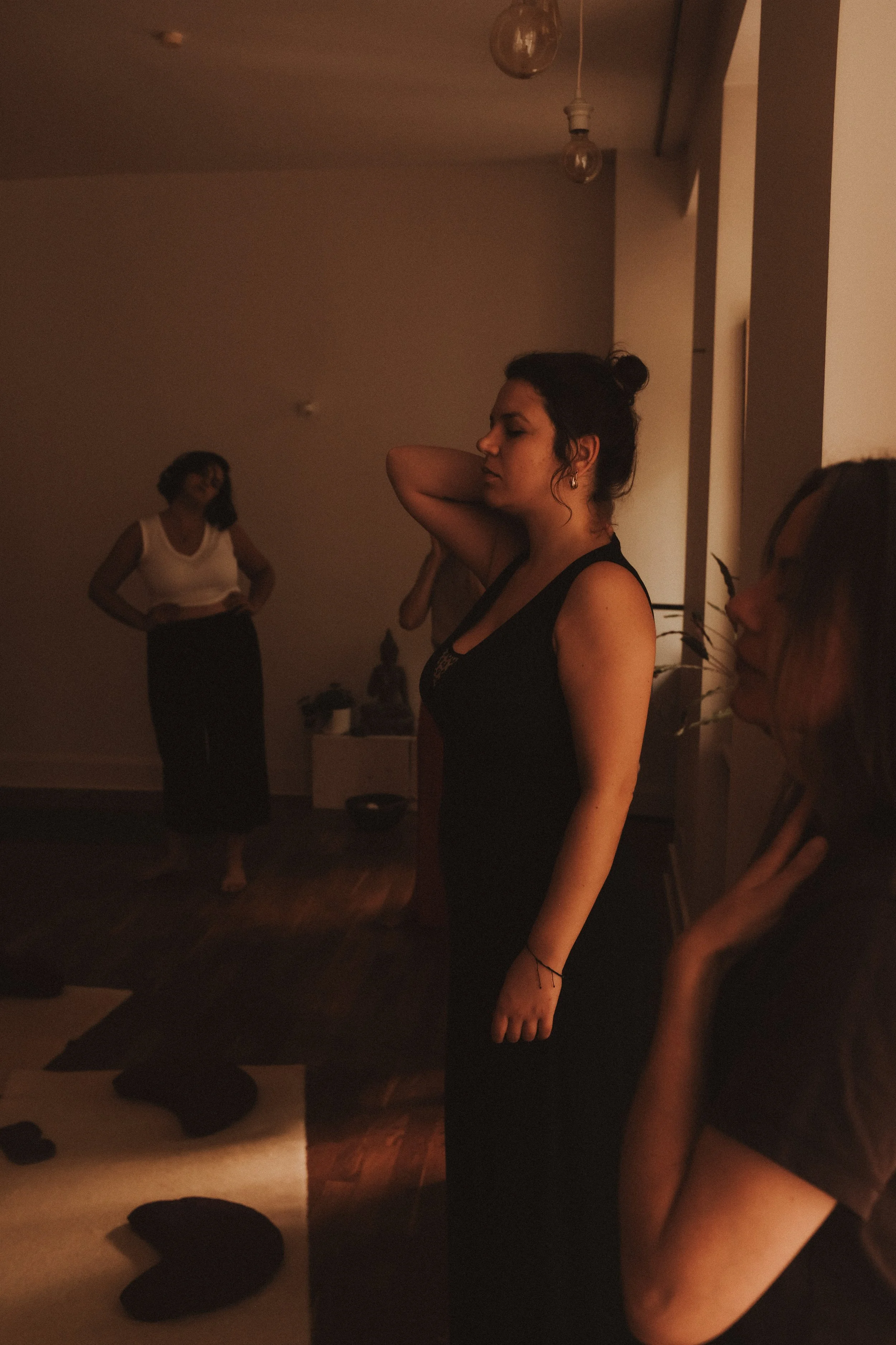 Menschen, die sich in einem dunklen Raum für eine Meditation oder Yoga üben, mit gedämpftem Licht und einer ruhigen Atmosphäre.