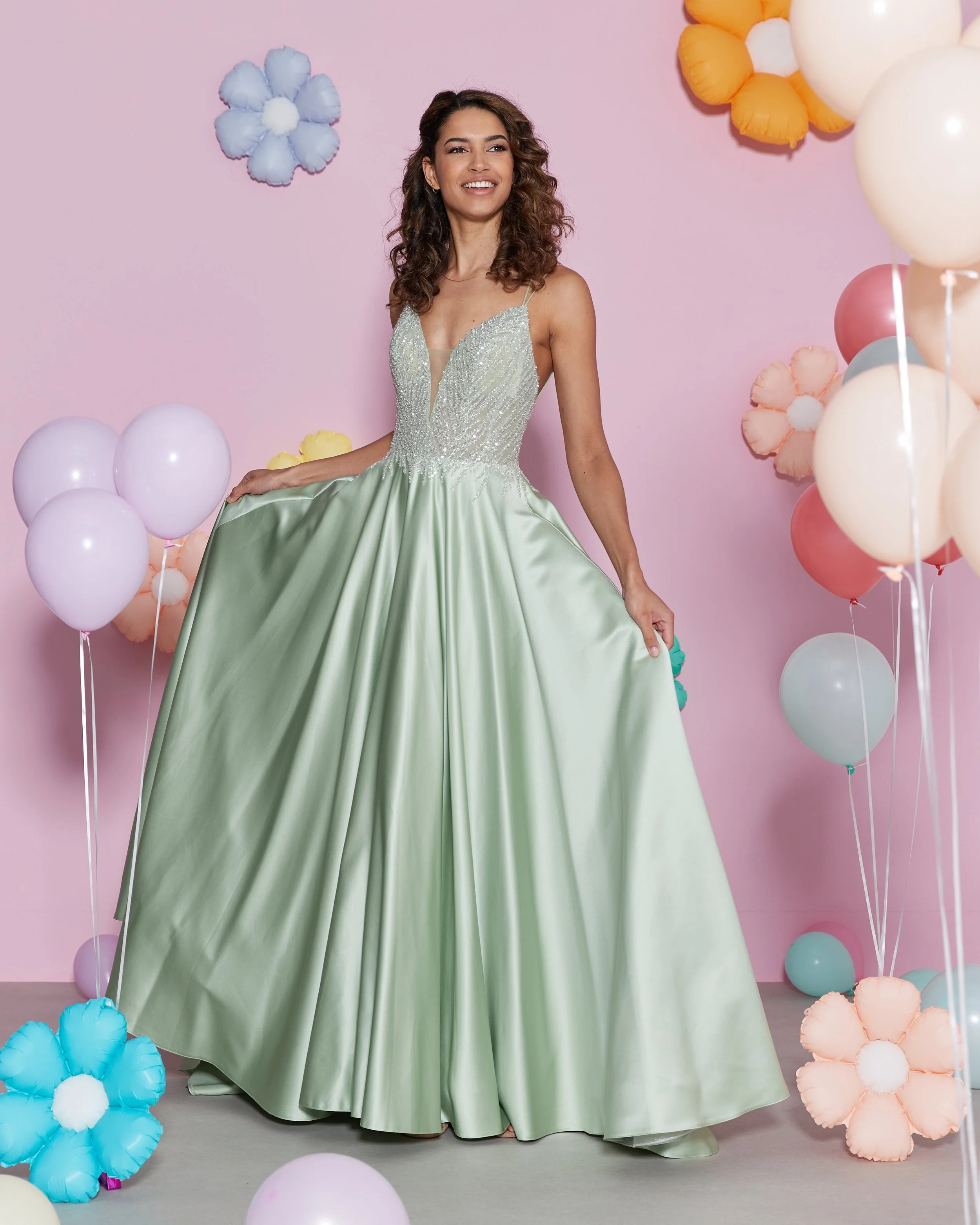 LI26005 - Mint UK8 | The stunning fitted bodice features intricate beading embellishments that cinch the waist, adding a touch of glamour. The deep V-neckline with a sheer panel creates captivating, modern look, while the low back has lace-up detail.
