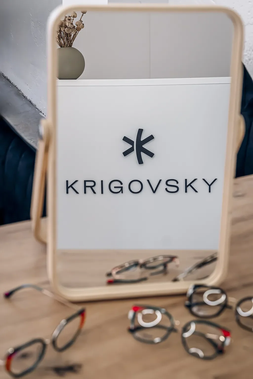 Logo Krigovsky v zrkadle s okuliarmi – Optika Krigovsky Poprad