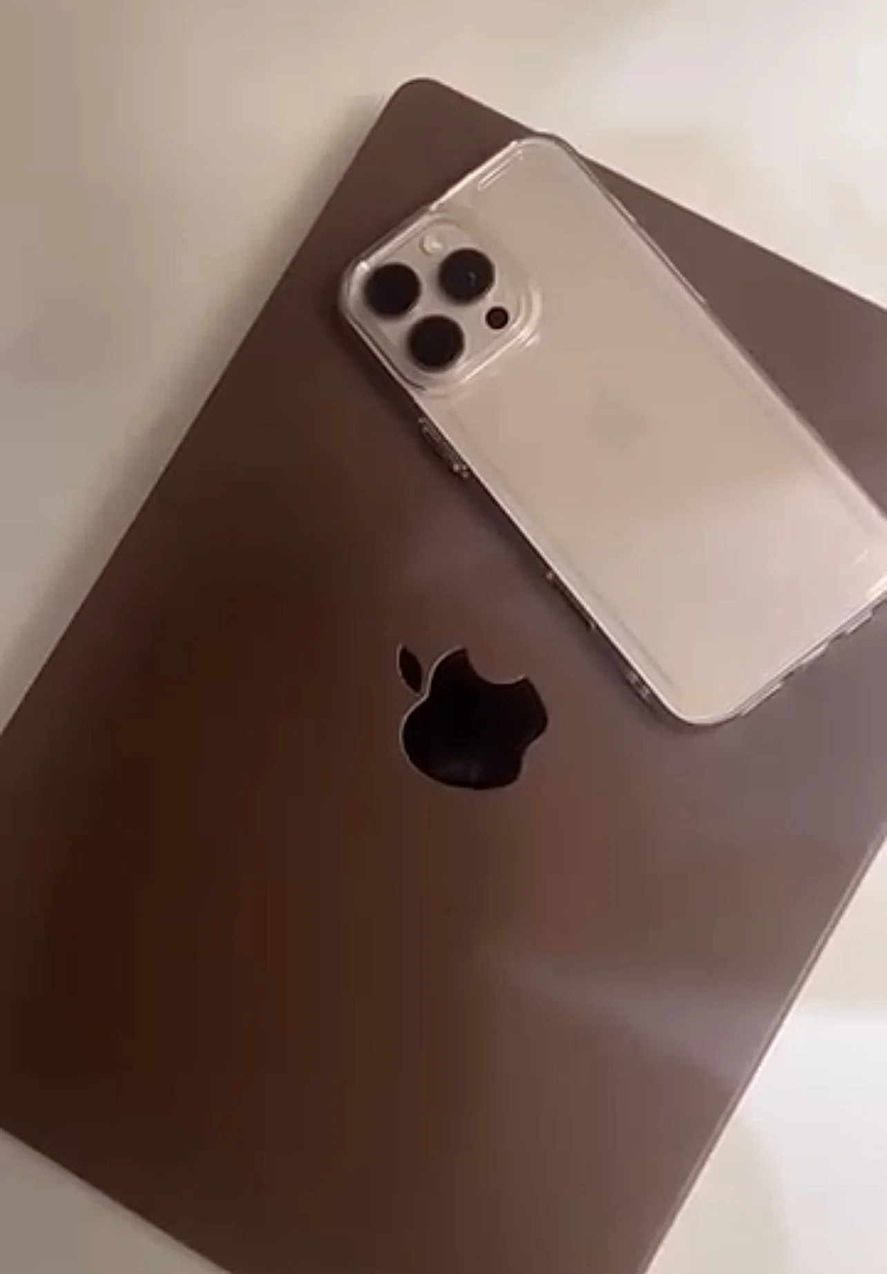 An iPhone with triple camera lens placed on a laptop.