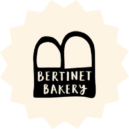 Bertinet Bakery logo with minimalist bread loaf icon and handwritten text on cream starburst background – artisan bakery brand