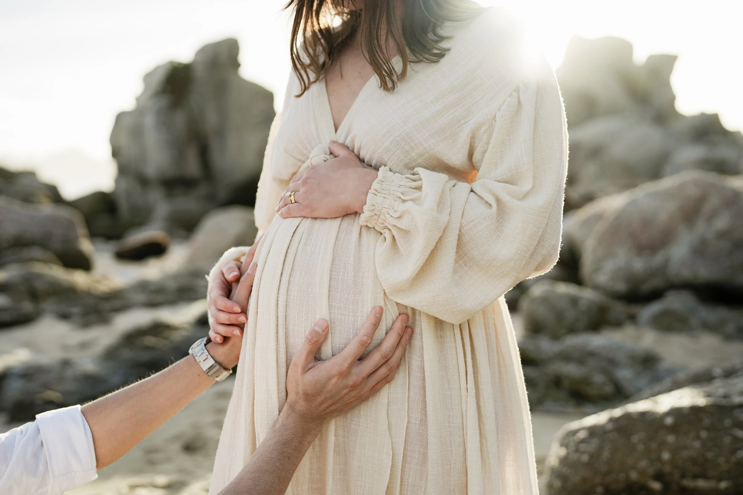 dad is touching the belly of mom for their maternity photography in Carmel.