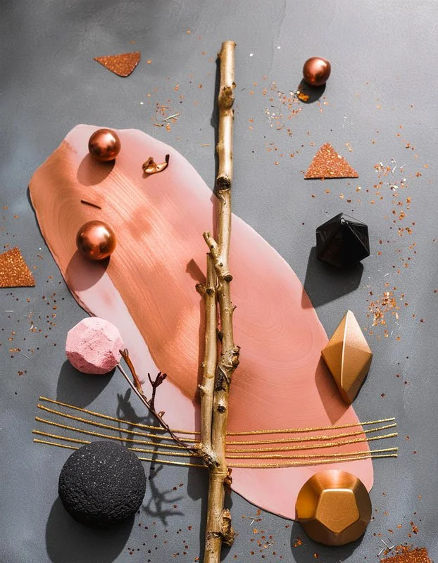 Abstrakter Kunsthintergrund mit verschiedenen geometrischen Objekten, Twigs und farbigen Materialien auf einer grauen Oberfläche.