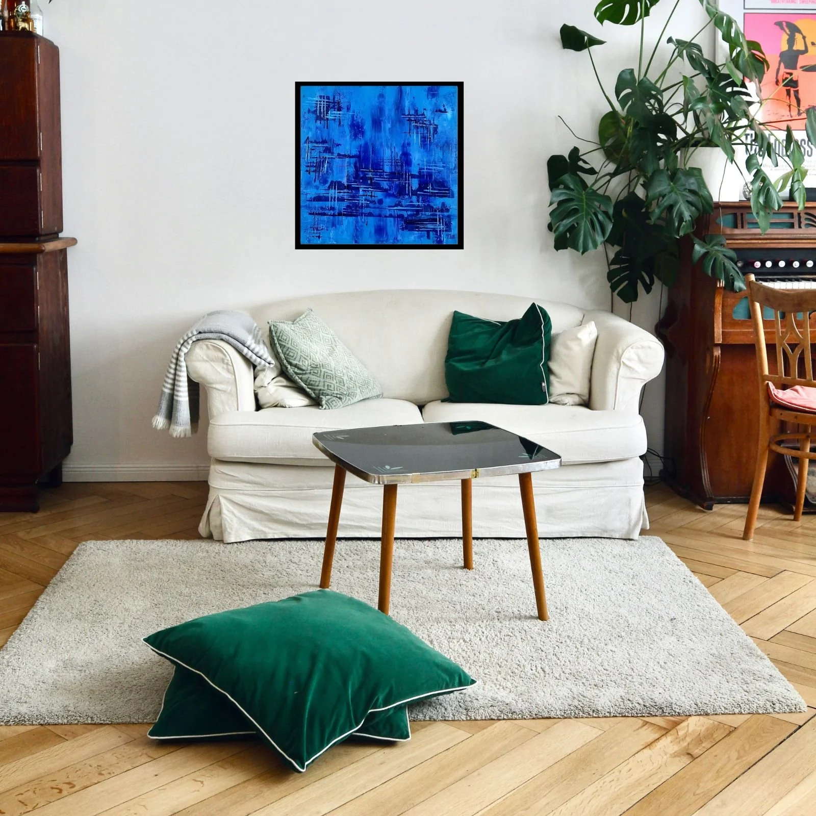 Pintura “Deep Into The Blues” em acrílico sobre tela, moldurada e exposta em sala de estar moderna com sofá branco e almofadas verdes, julho de 2020, HMad Artworks.