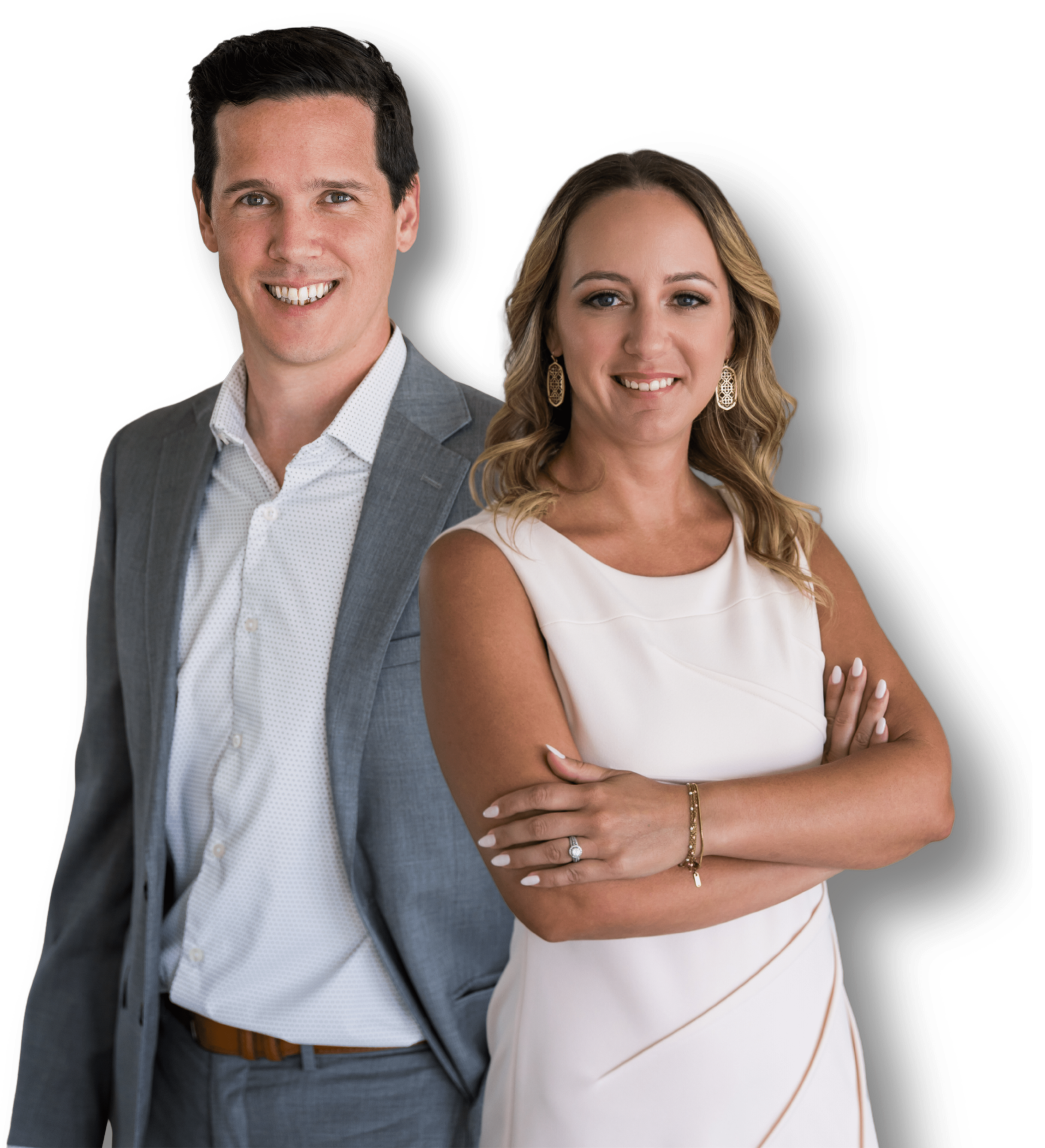 A man in a gray suit with a white shirt, and a woman in a sleeveless white dress with gold earrings, standing close together and smiling.