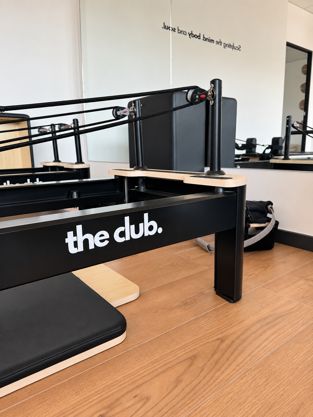Une table de tennis de table avec un filet, et une surface de jeu blanche. En arrière-plan, plusieurs bureaux et chaises dans un espace de travail moderne.