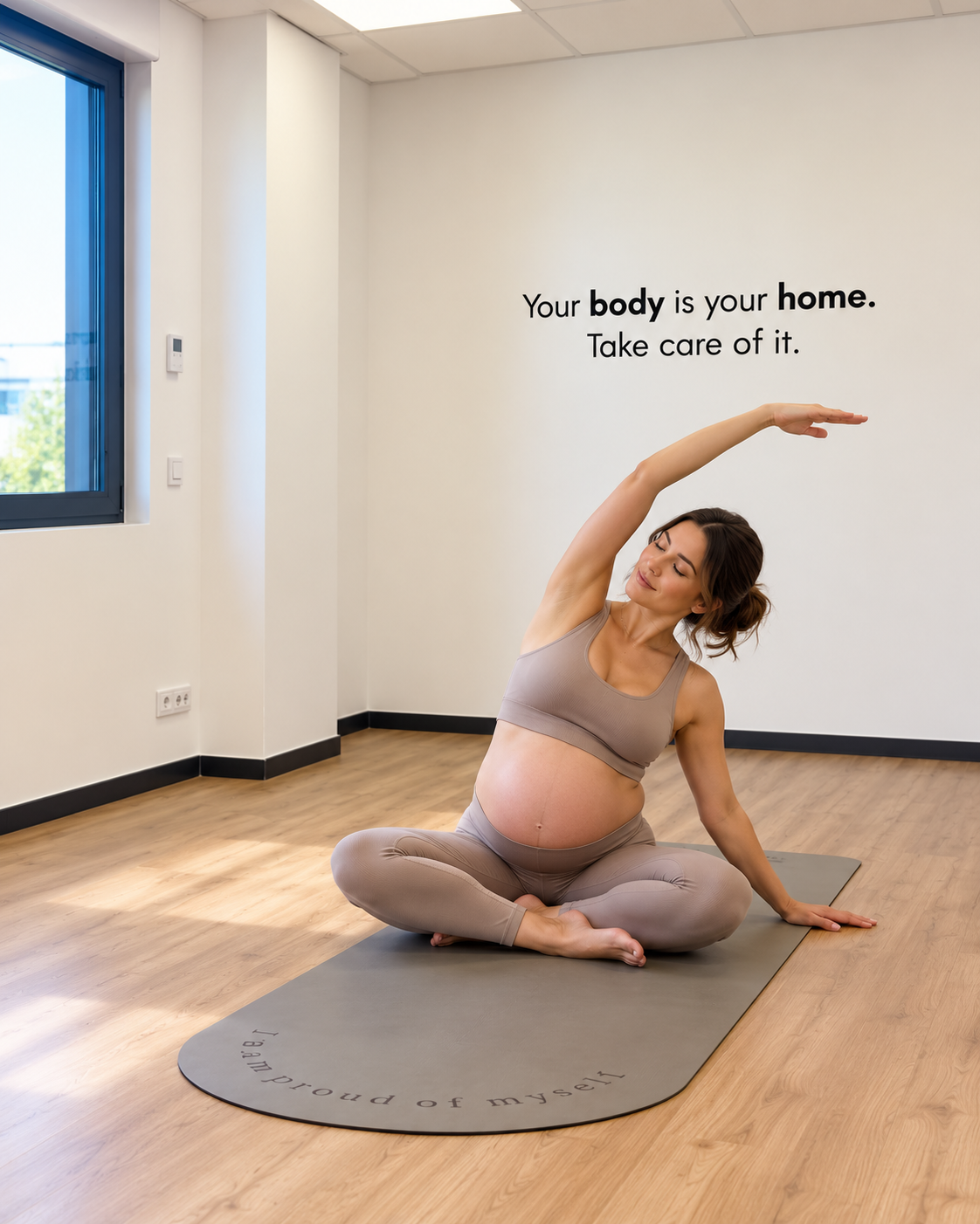Femme enceinte jouant avec un ballon de fitness, en position de squat, en vêtements de sport, dans une image en noir et blanc.
