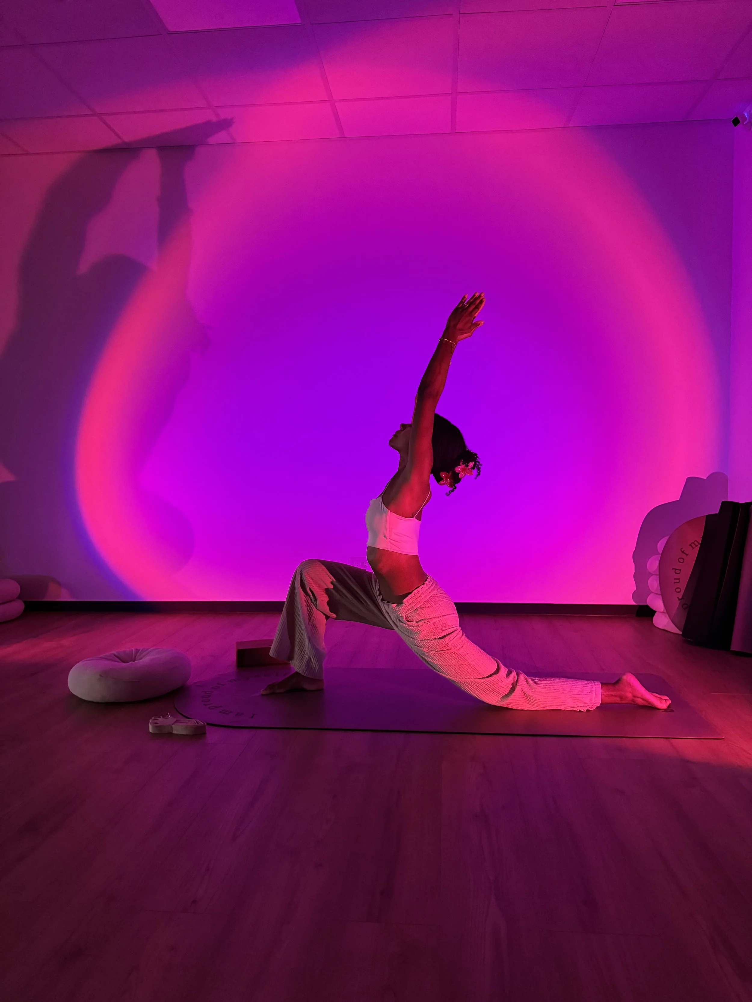 Femme pratiquant une posture de yoga assise, en position de flexion vers l'avant, sur un tapis