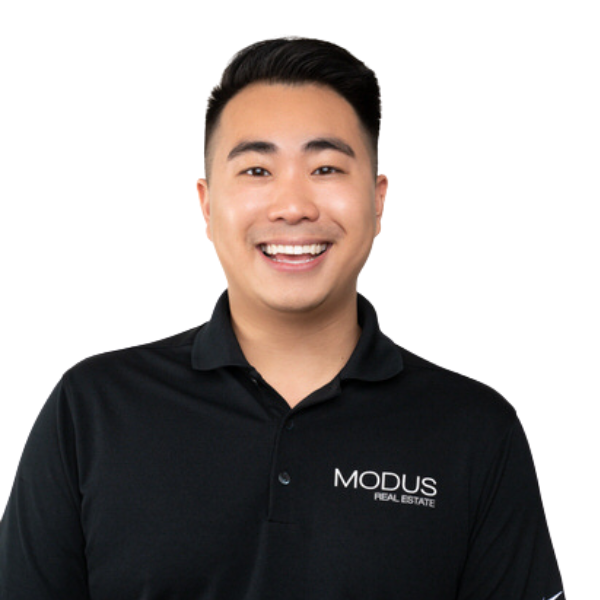 A smiling man wearing a black polo shirt with 'MODUS REAL ESTATE' logo.